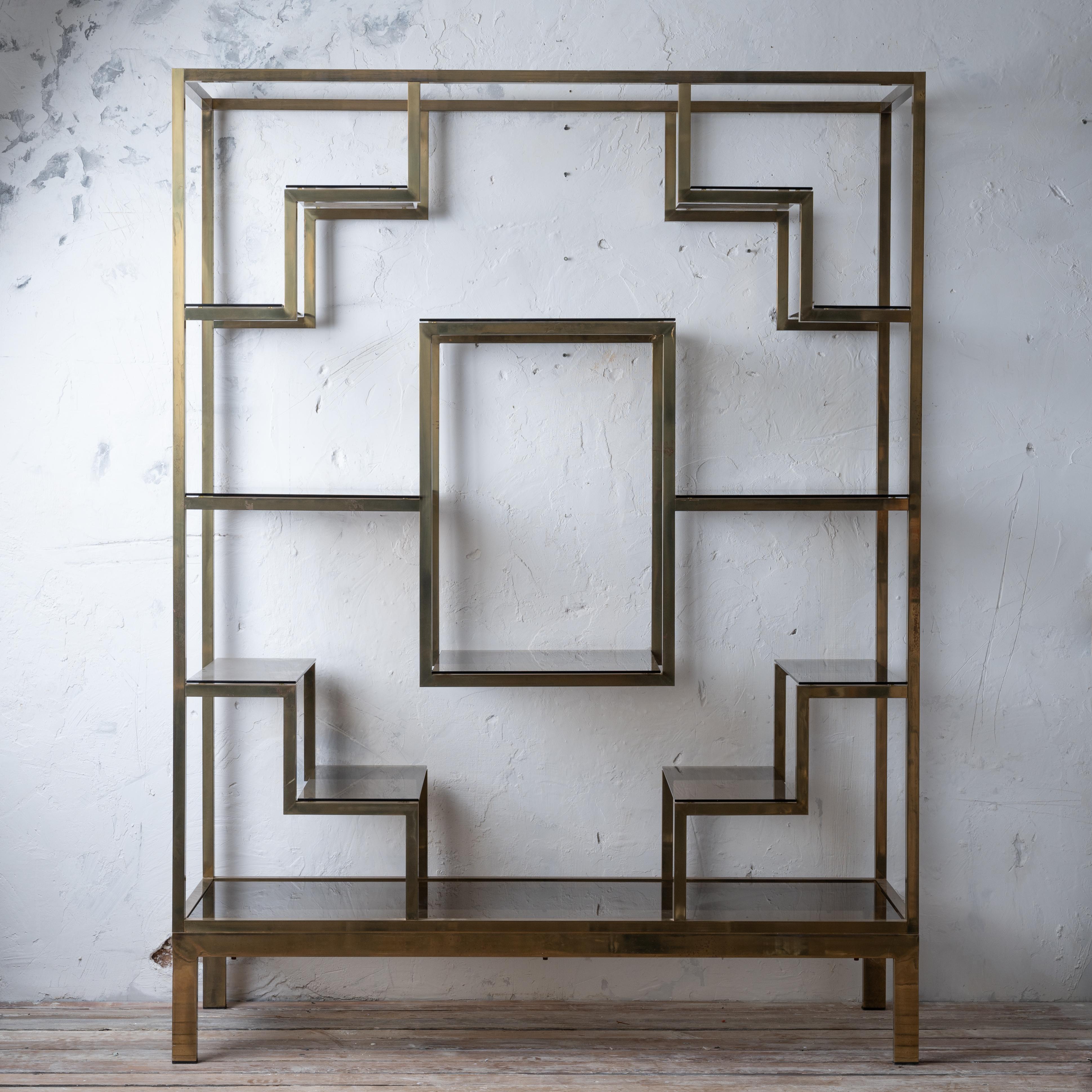 An Italian brass and smoked glass etagère by Romeo Rega, circa 1970. 

59 ¾ inches wide by 19 ¼ inches deep by 79 ½ inches tall

