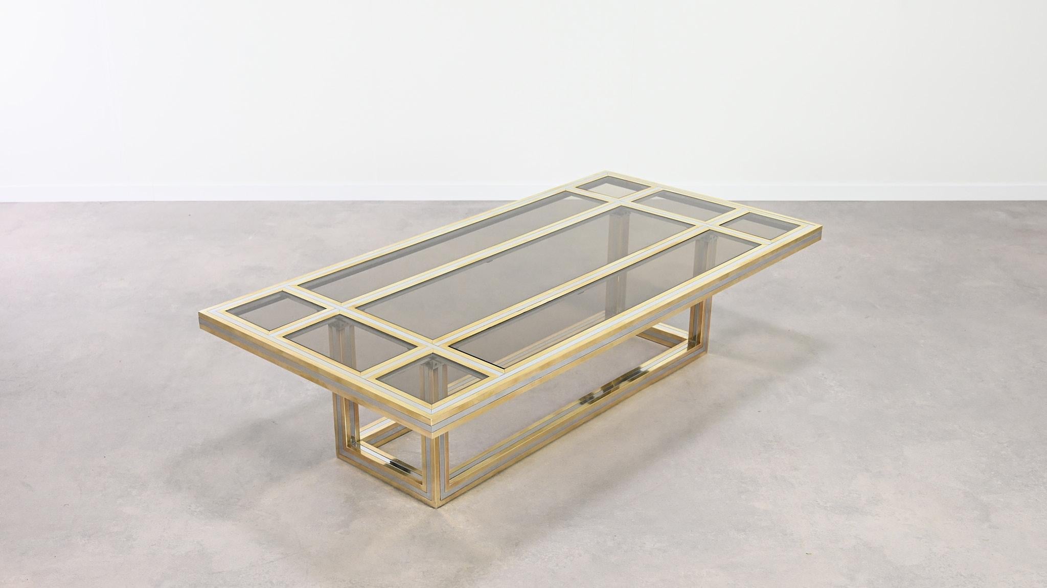 Elegant coffee table by Italian designer Romeo Rega. This coffee table, designed and manufactured in the seventies, is made of a brass and chromed brass structure featuring smoked glass plates on the top. The table is not signed, as not every Romeo