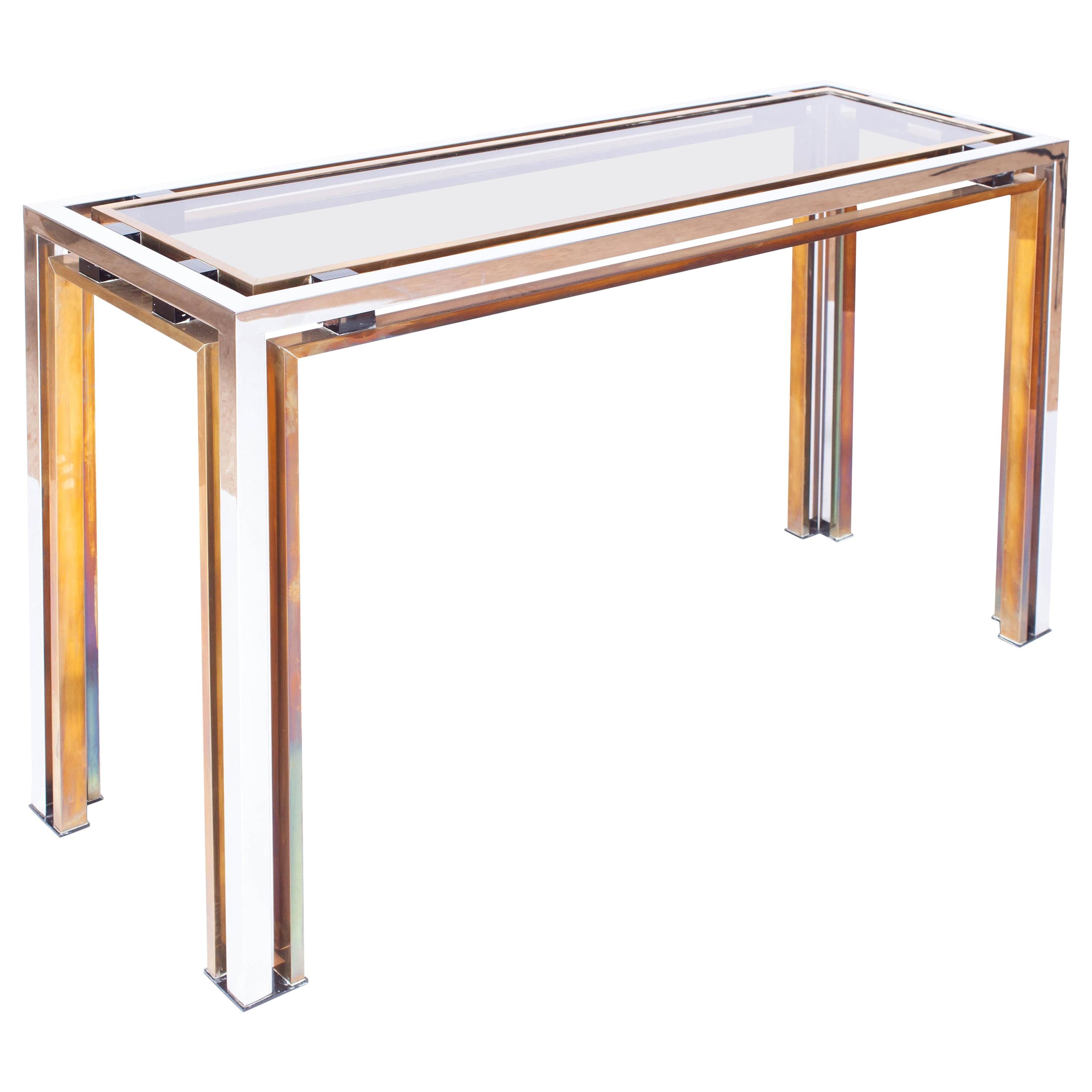 Hollywood Regency, console table, Romeo Rega, Italy, the 1970s.

The sculptural chrome and brass frame is contrasting nicely with the smoked glass top which is held in place with purple perspex details.
Eclectic international style decor.
 
