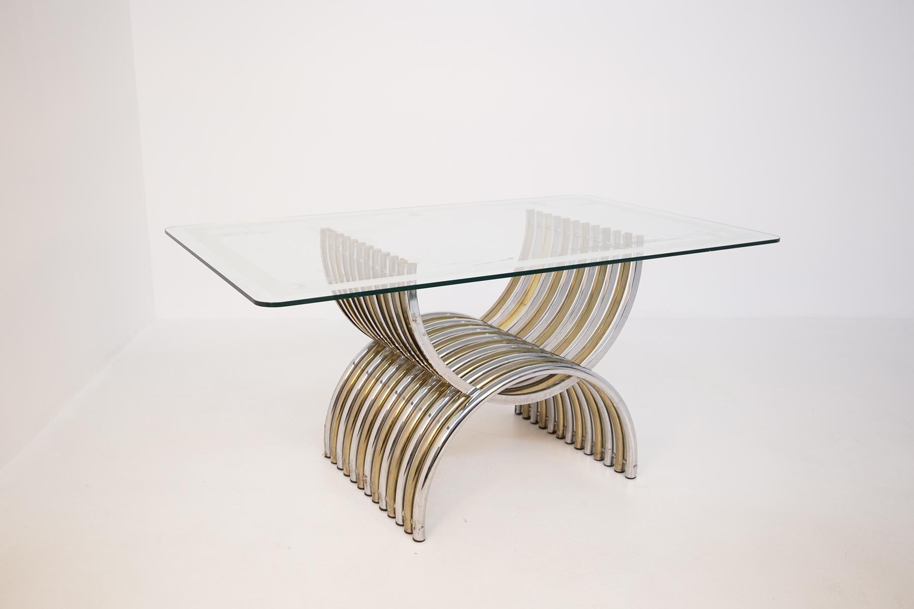 Elegant dining table by Romeo Rega from the 1970s. The table is made with a rectangular shaped glass top with a mirrored edge. 
The great peculiarity of the table is its base structure. The spectacular structure made of tubular steel both chrome