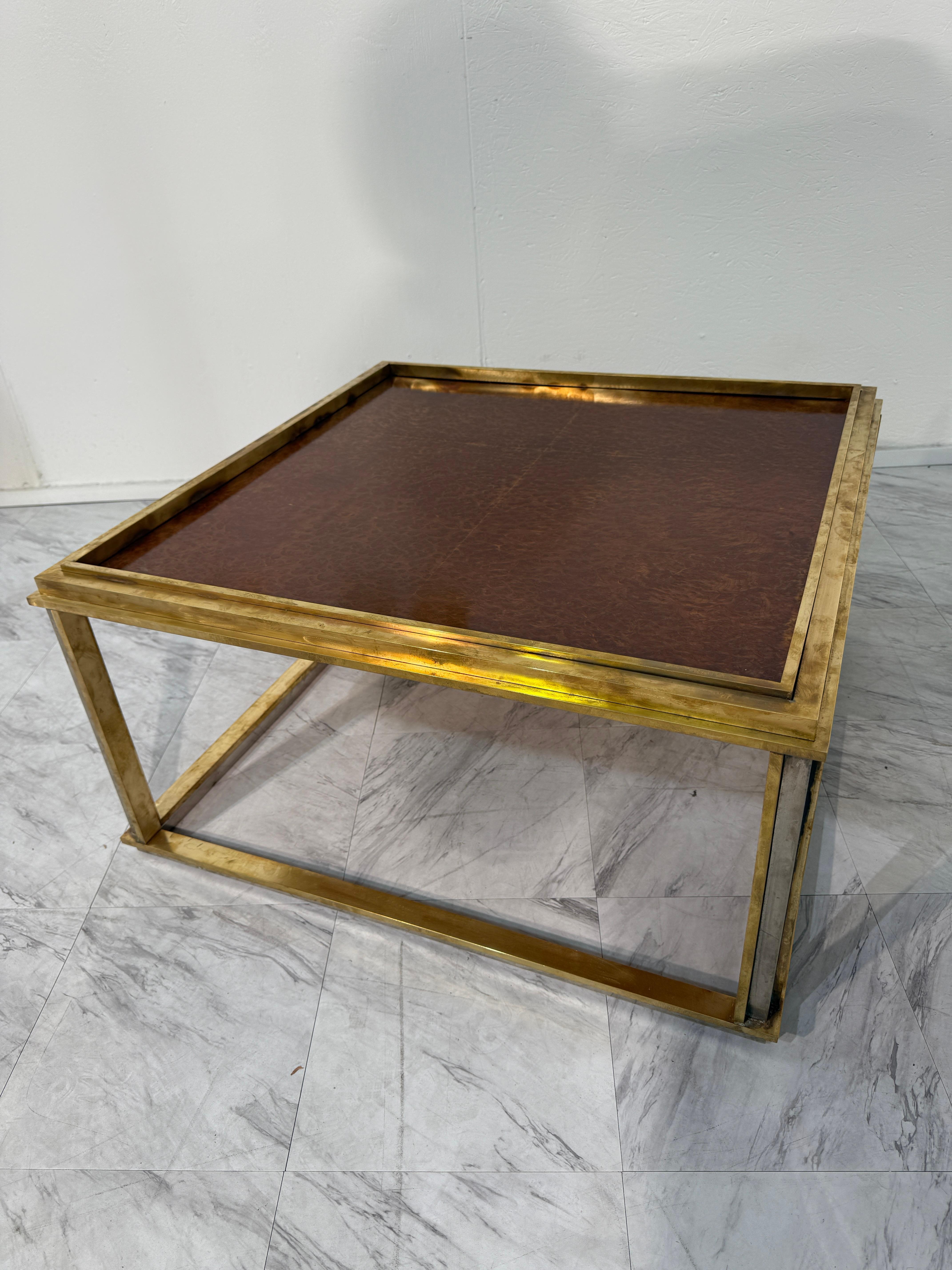Un raffinato tavolino quadrato del famoso designer italiano Romeo Rega, realizzato negli anni Settanta. Questo tavolo quadrato presenta una struttura in ottone scintillante dalle linee geometriche pulite, abbinata a un piano in legno di radica che
