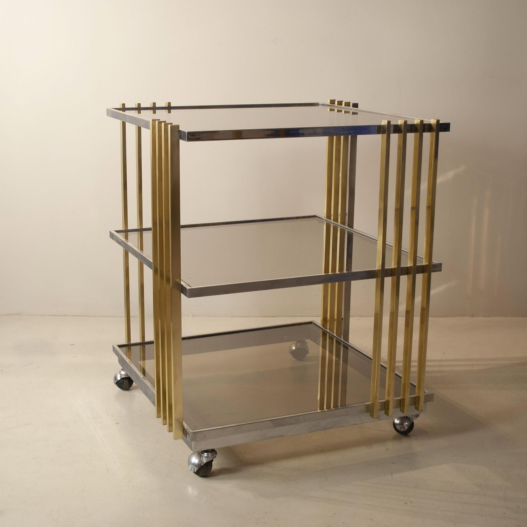 Elegant 70's trolley bar in brass and steel, smoked glass shelves, attr. designer Romeo Rega.
Romeo Rega is born in Rome on 10 October 1925, third of six children, born and raised in the Trastevere district, in the heart of Rome.  THE FIRST BIG