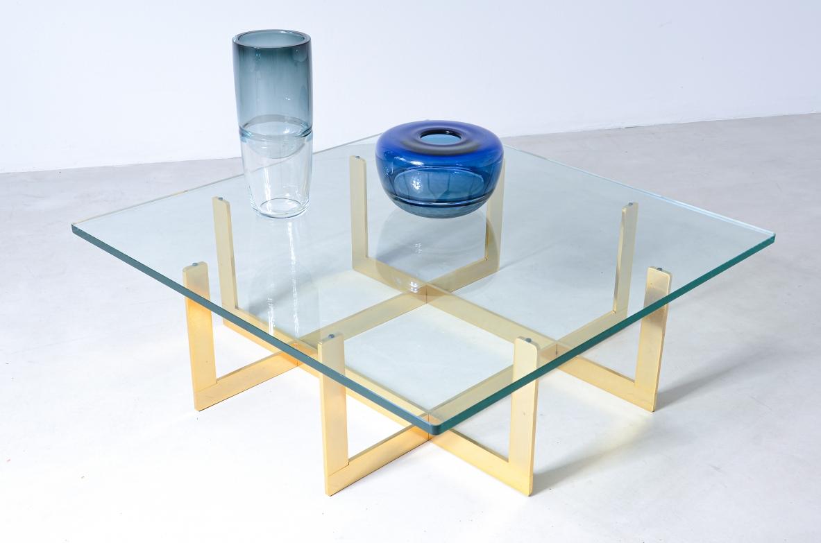 Eleganter, niedriger Tisch mit Messingstruktur und dicker, geformter Kristallglasplatte.

Italienische Herstellung, um 1970.