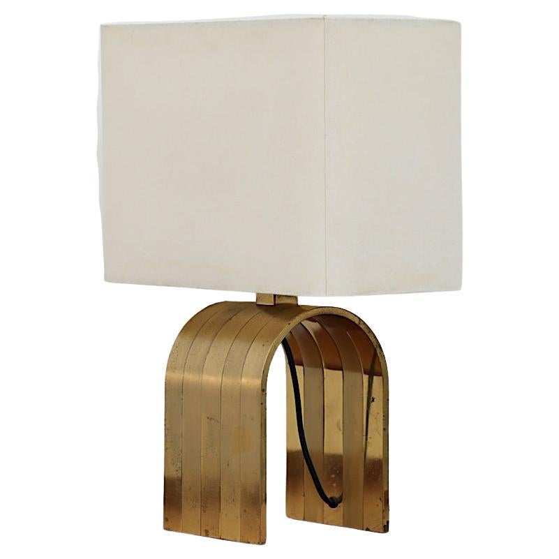 Beautiful Romeo Rega style curved mixed brass table lamp with linen shade. In original condition with visible patina and some tarnishing, minor denting and. staining on shade. Wear is consistent with age. Shown with Danish teak Vanity-Dresser and
