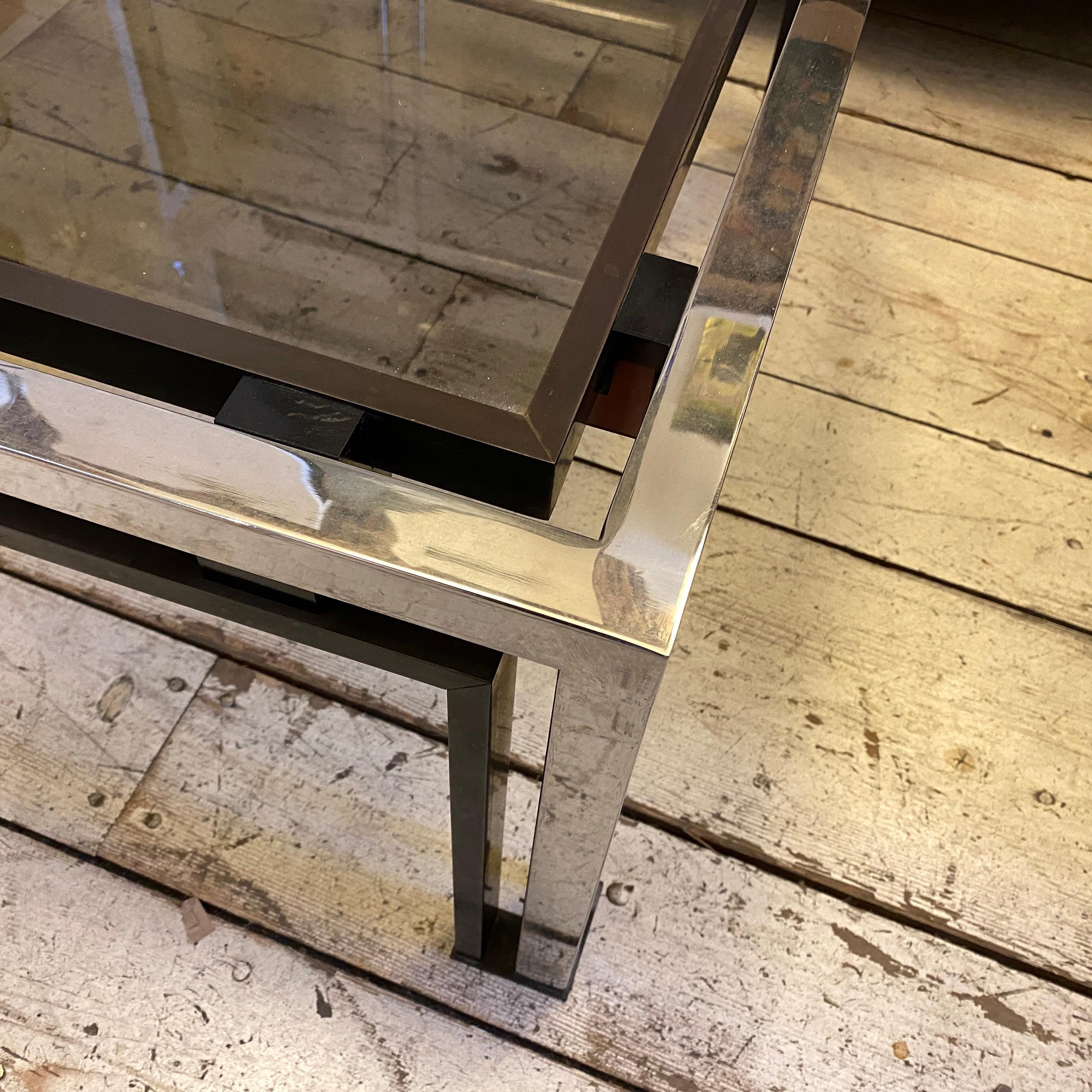A coffee table made in Italy in the 1970s. The brass it's in original patina, as you can see in the last photo it's easily cleanable. Smoked glass and chromed parts are in perfect conditions.