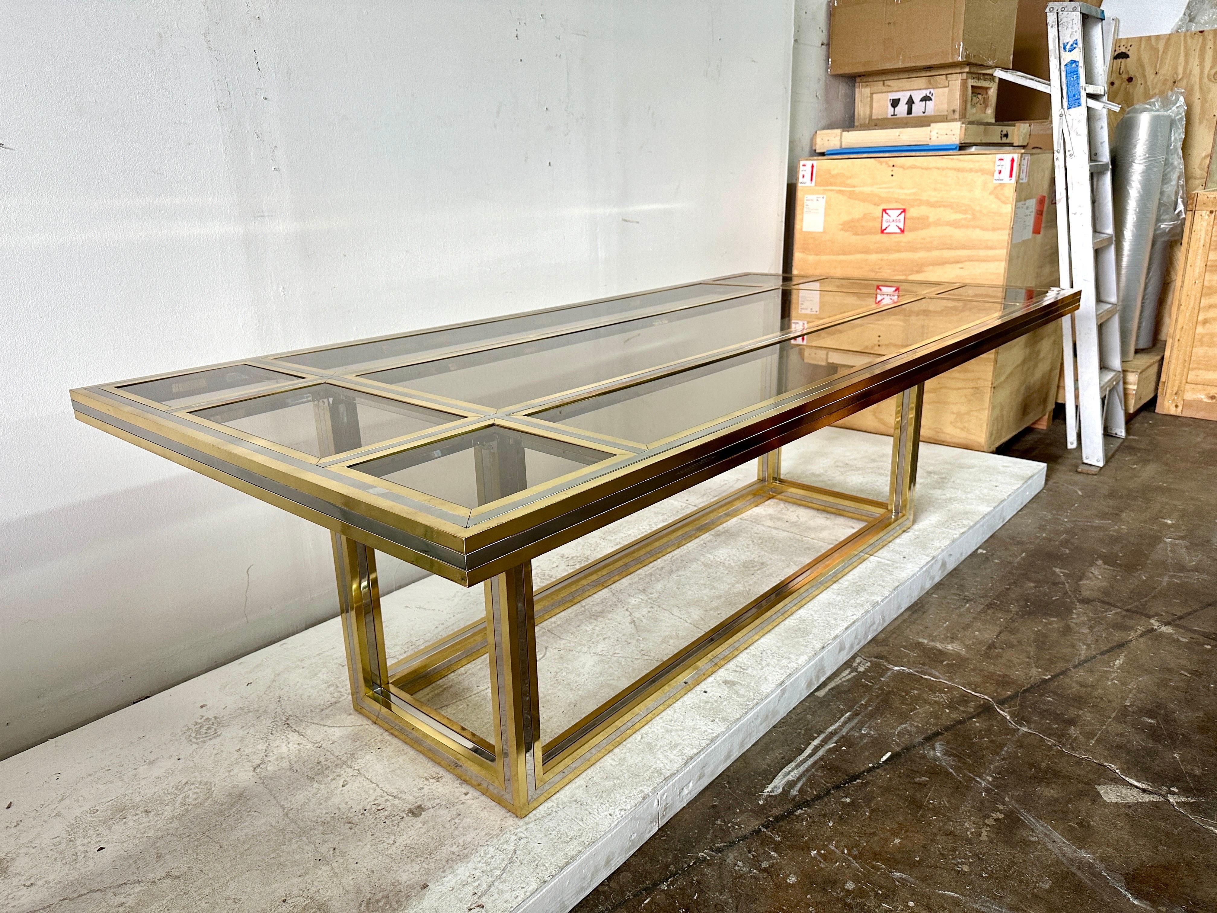 Vintage SIGNED Romeo Rega mixed-metals dining table with 9 glass insets (lightly smoked glass).  The table is heavy and solid, a true design masterpiece from the 1970's.  There are a few areas where the brass has taken on a darker patina.  NOTE: