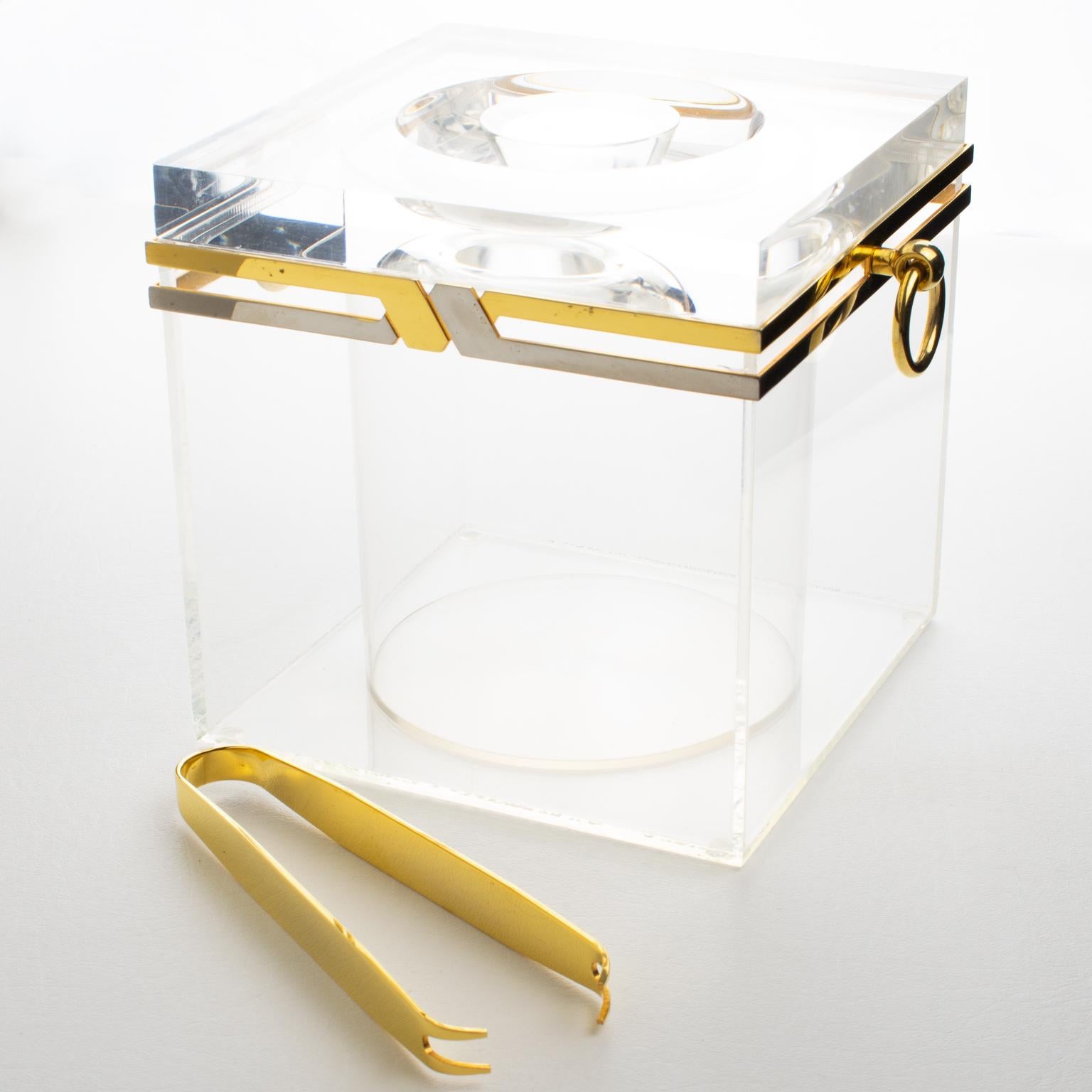 Este elegante accesorio de bar incluye una cubitera y unas pinzas, perfectas para un bar o una fiesta de cócteles. Su diseño se atribuye a Romeo Rega, Italia, hacia 1970. El utensilio de bar presenta un marco metálico de latón cromado y dorado con