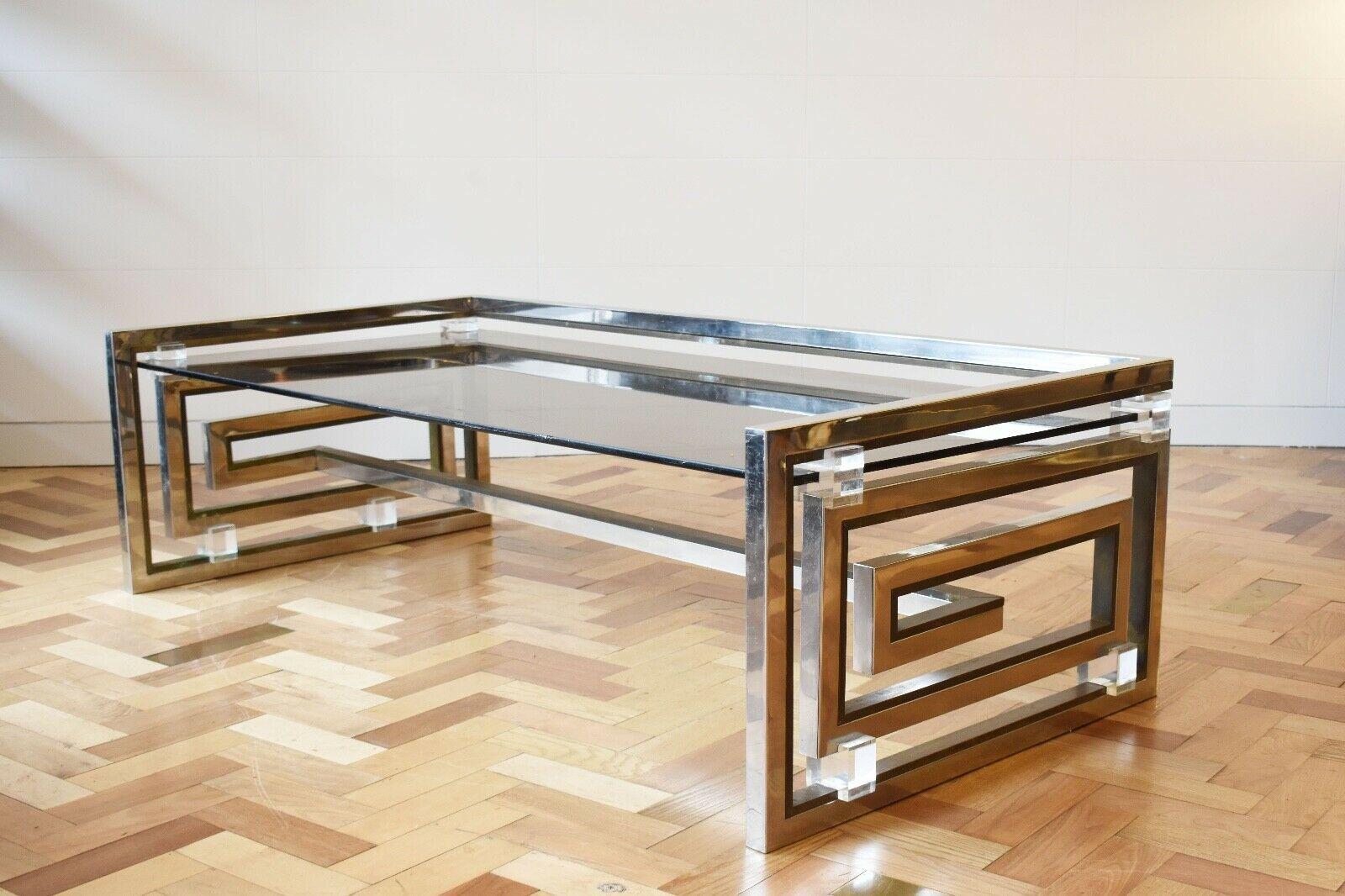Spectacular coffee table designed by Romeo Rega, Italy, 1970's.

This beautiful coffee table is made from a chrome and brass frame which has been designed as a modernist greek key form, accented with lucite blocks which hold the coffee tables