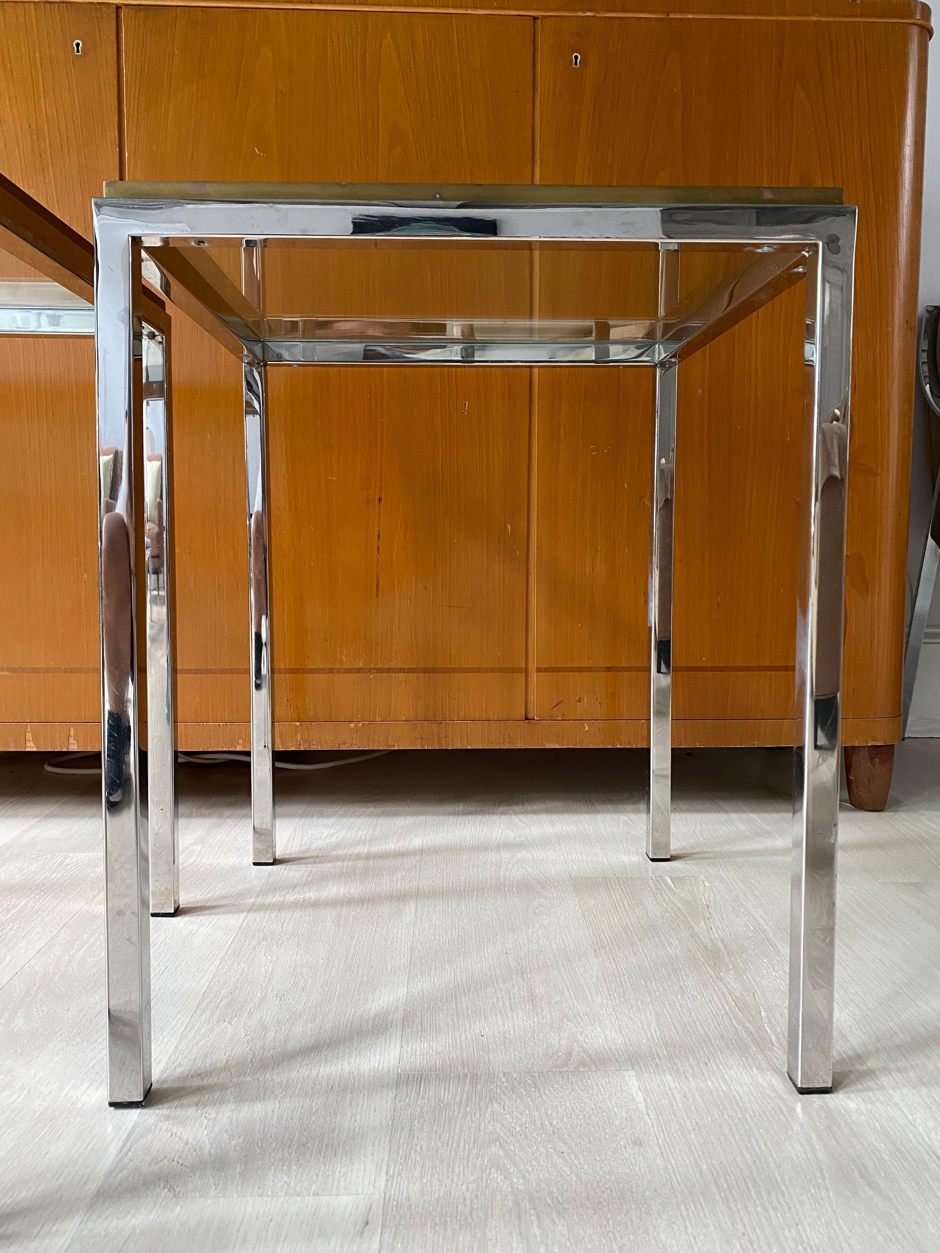 Estupendo par de mesas auxiliares Romeo Rega de base cromada bien trabajada con detalles de latón incrustado en la suela, todo ello con un buen peso.

Dimensiones aproximadas:
20 x 20 x 25-1/8 pulgadas de alto

Puedo recomendarte transportistas para