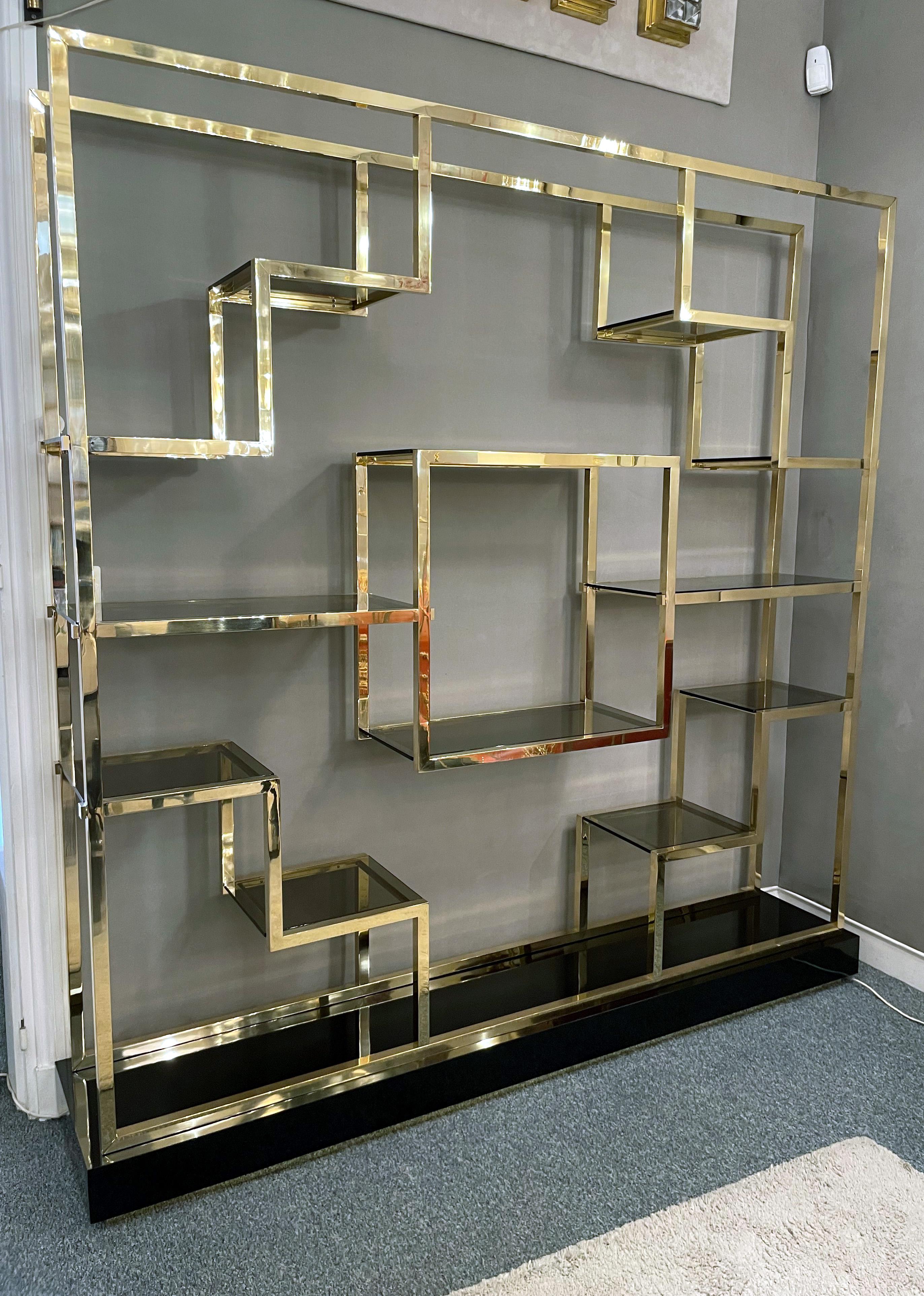 Shelf and/or room divider by Romeo Rega, Italy, 1970s. 
Polished brass and smoked glass, with a base of black lacquered wood on a recessed brass plinth.

   