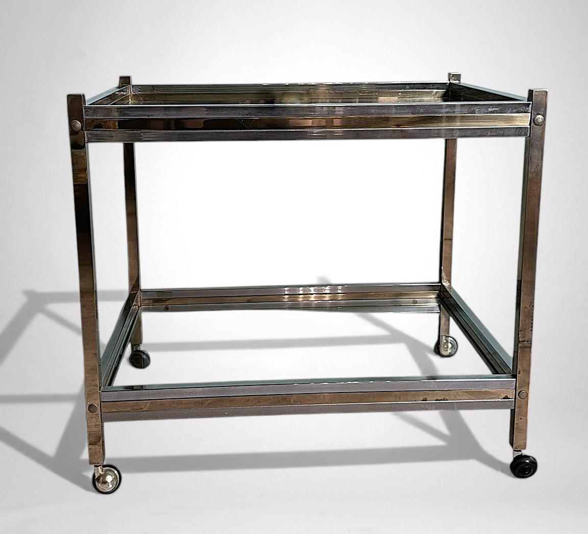 Elegante carrello da bar italiano degli anni '60, realizzato con una raffinata combinazione di ottone lucido e acciaio, un approccio tipico della migliore metallurgia italiana del periodo e pienamente in linea con l'estetica modernista post-1958. La