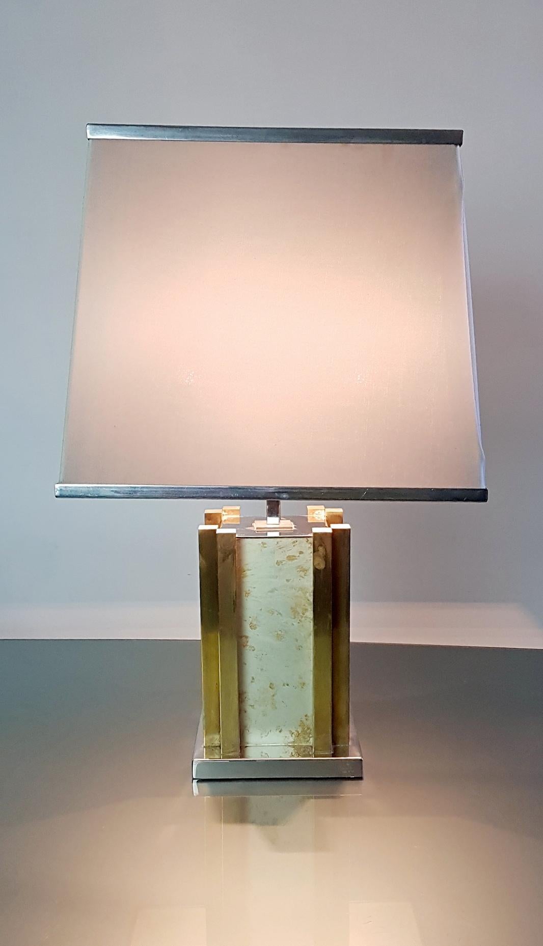 A signed table lamp by Romeo Rega with a chrome and brass base and faux stone sides. Original lampshade in white fabric and chrome. Uses two E27 lightbulbs. In very nice condition.