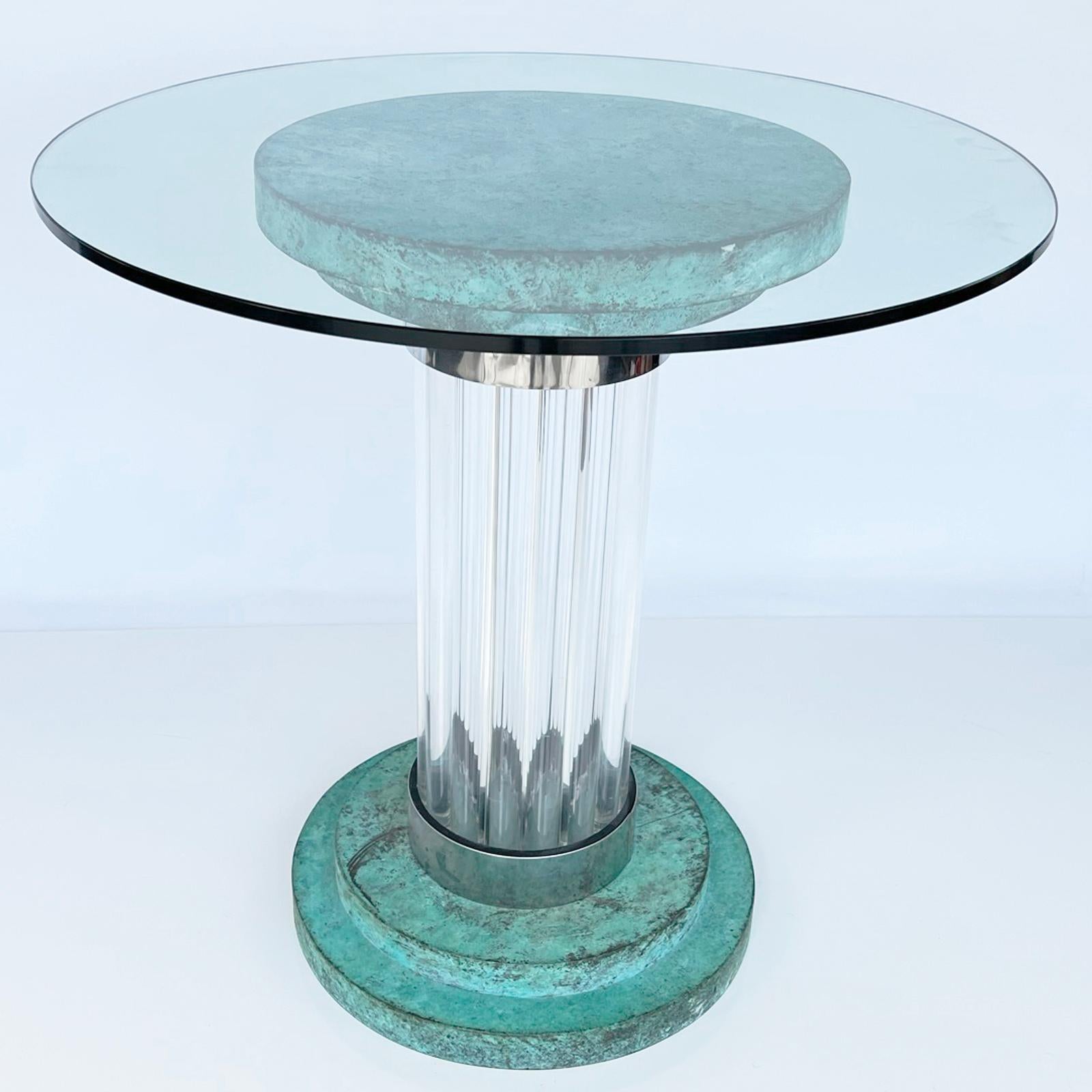 Sockeltisch von Romeo Rega mit runder Glasplatte, auf einem Sockel aus abgestuften Kupferscheiben mit Grünspan-Finish, erhöht auf einer Säule aus Lucite-Stäben mit verchromten Metallbändern, auf passendem abgestuften Sockel. 

Der Tisch kann als