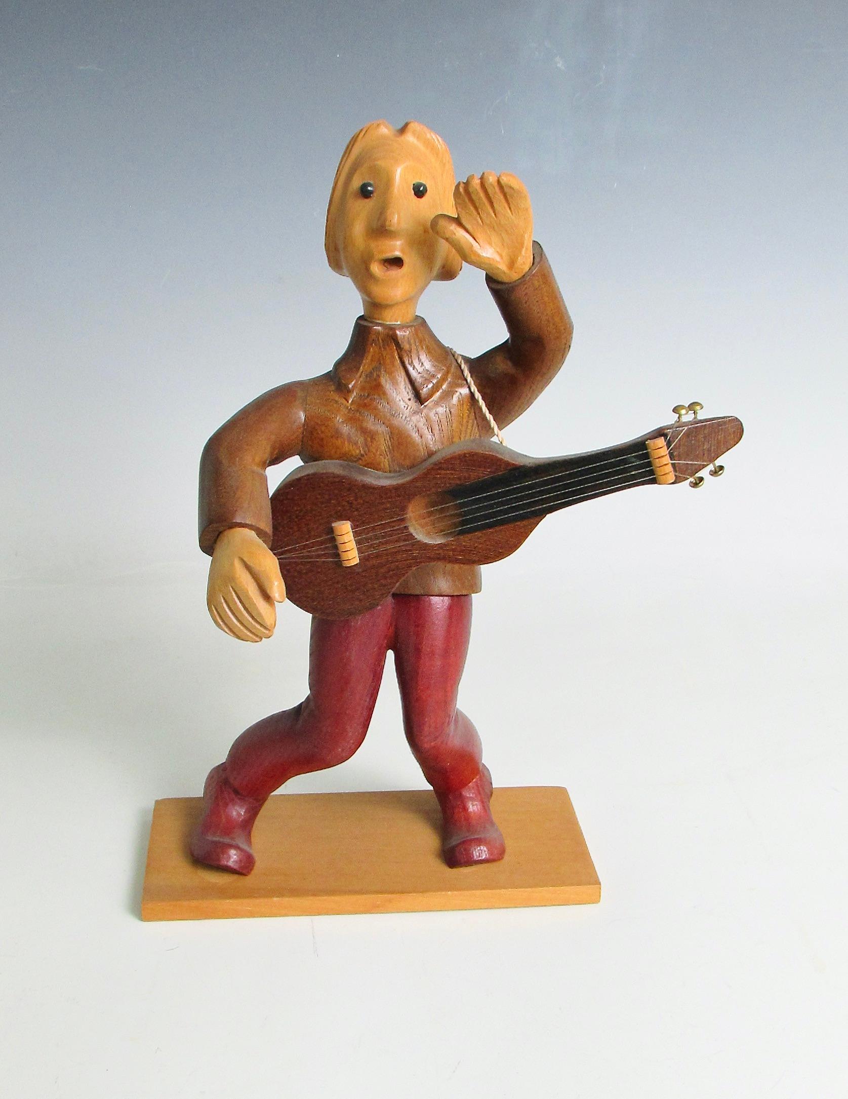 Caprichosa figura tallada de un  guitarrista de rock and roll  . Tallado a mano en Italia de finales de los 60 a los 70 . Esta es una de las muchas figuras talladas que representan oficios y aficiones .  Fabricado por la empresa Romer  Italia . Se