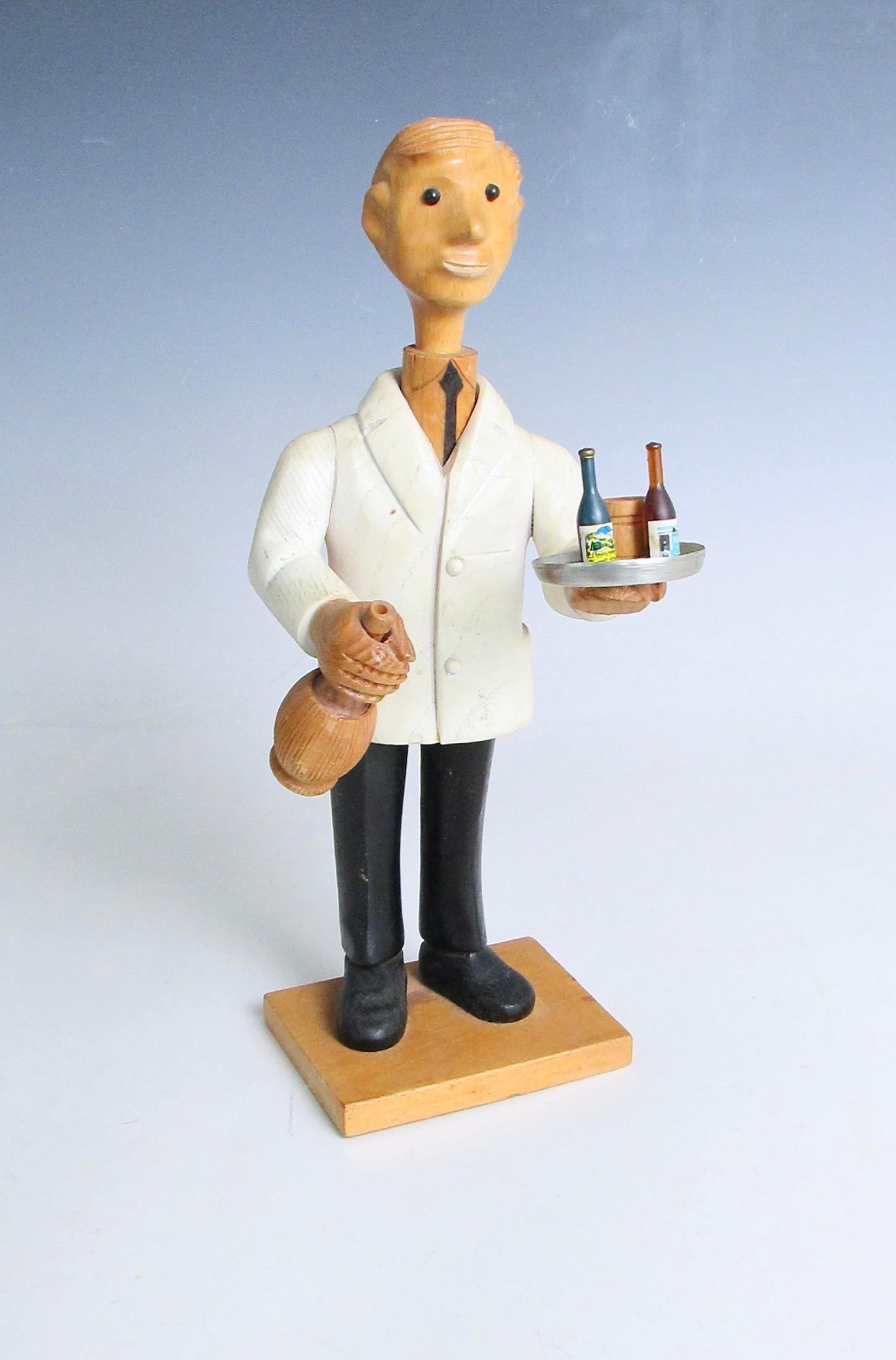 Figura divertida y bien tallada de un camarero con smoking blanco que sostiene una botella de Chianti y una bandeja con bebidas . Tallado a mano en Italia de finales de los 60 a los 70 . Esta es una de las muchas figuras talladas que representan