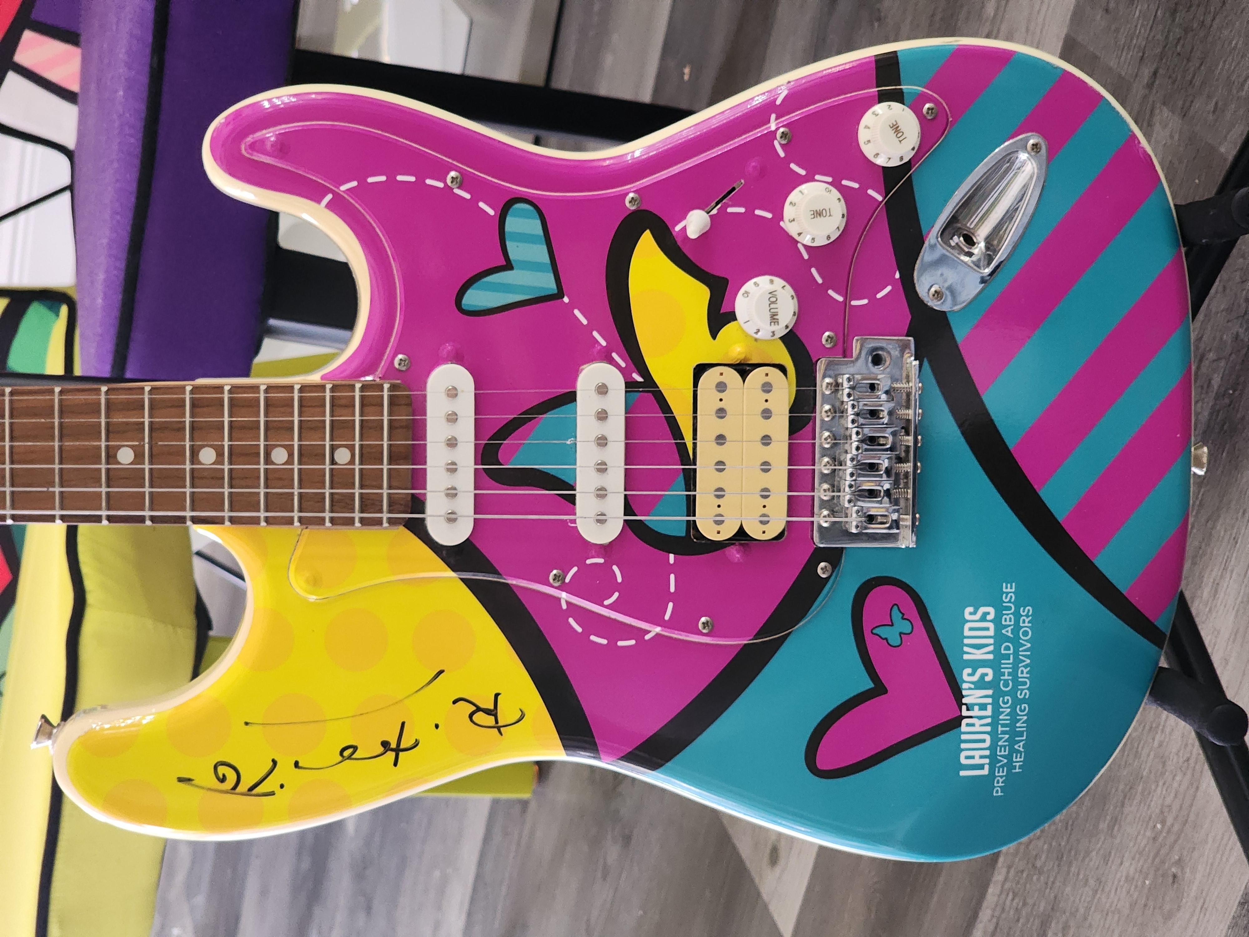 Artist: Romero Britto
Signed one of a kind, 'Glen Burton' electric guitar by BGuitars. The guitar helped to raise 1M dollars for Lauren's kids foundation - An organization that educates adults and children to prevent sexual abuse and heal survivors.