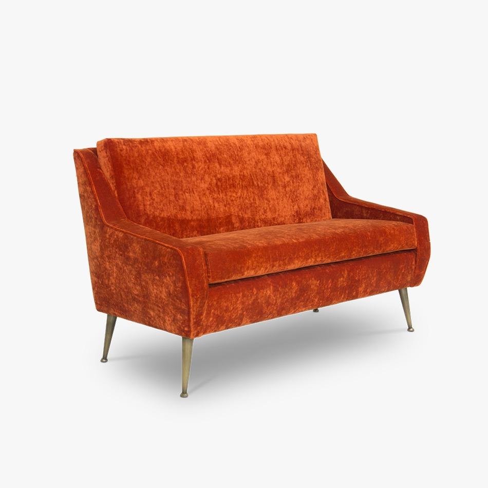 Like the other pieces from Russel collection, this futuristic sofa is designed with edgy lines. It has a stylistic open back and sloping armrests that merge with the luxurious velvet upholstery. This unique design is then supported by a polished