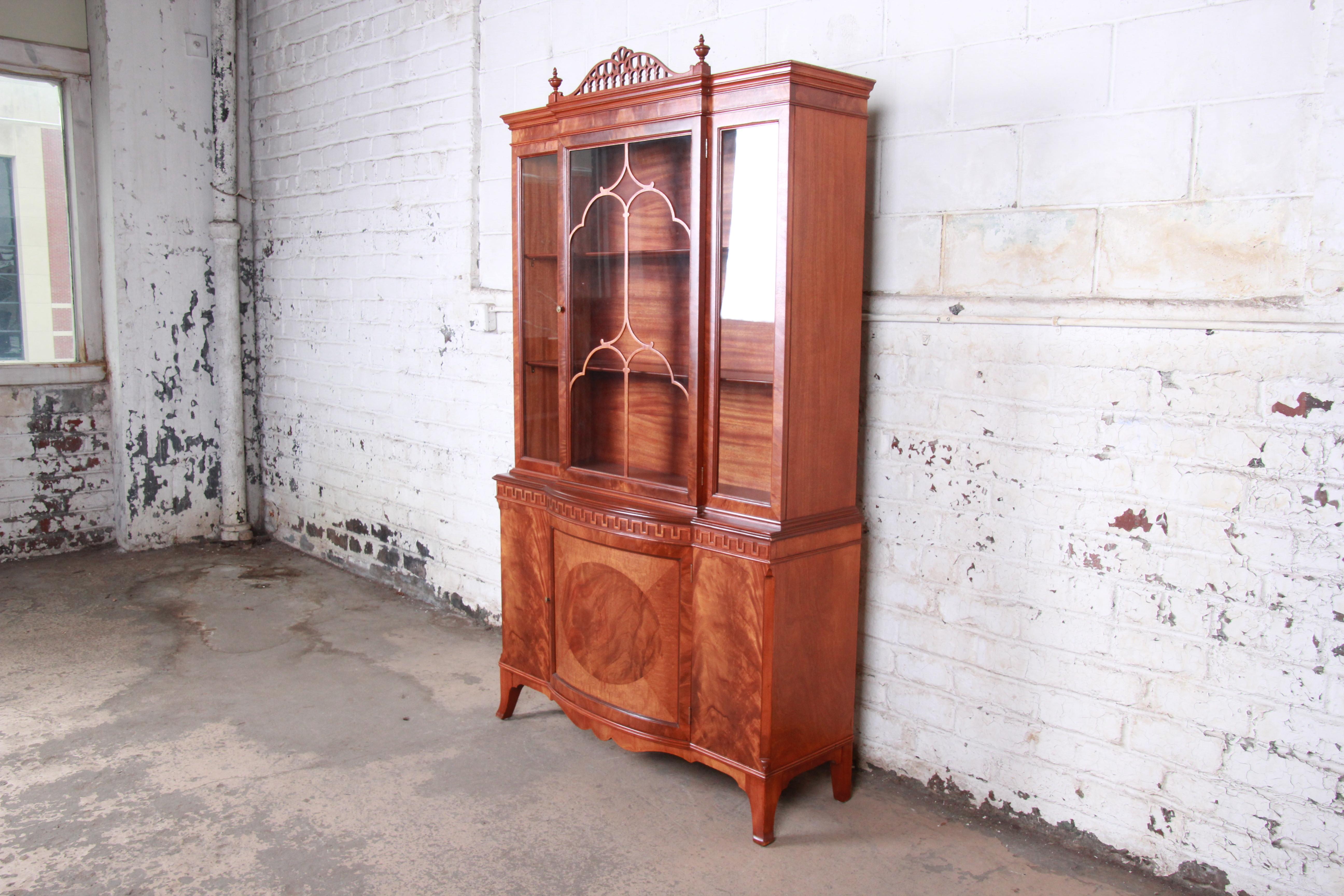 A gorgeous inlaid flame mahogany breakfront china display cabinet or bookcase

By Romweber

USA, circa 1940s

Bookmatched flame mahogany and brass hardware

Measures: 44.13