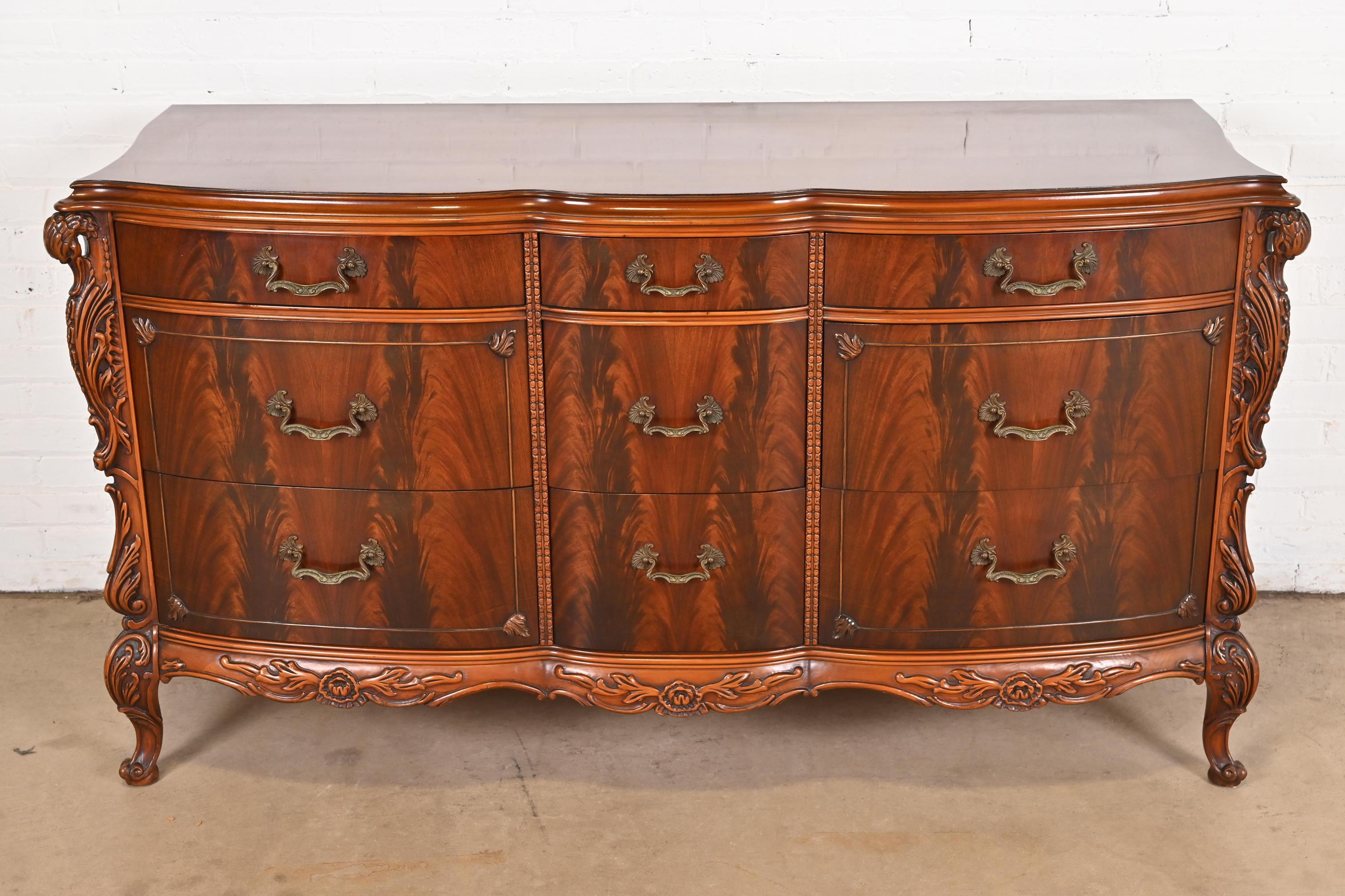 An exceptional French Provincial Louis XV style nine-drawer dresser or credenza

By Romweber

USA, Circa 1930s

Stunning book-matched flame mahogany, with carved swan heads, and original brass hardware.

Measures: 66.5