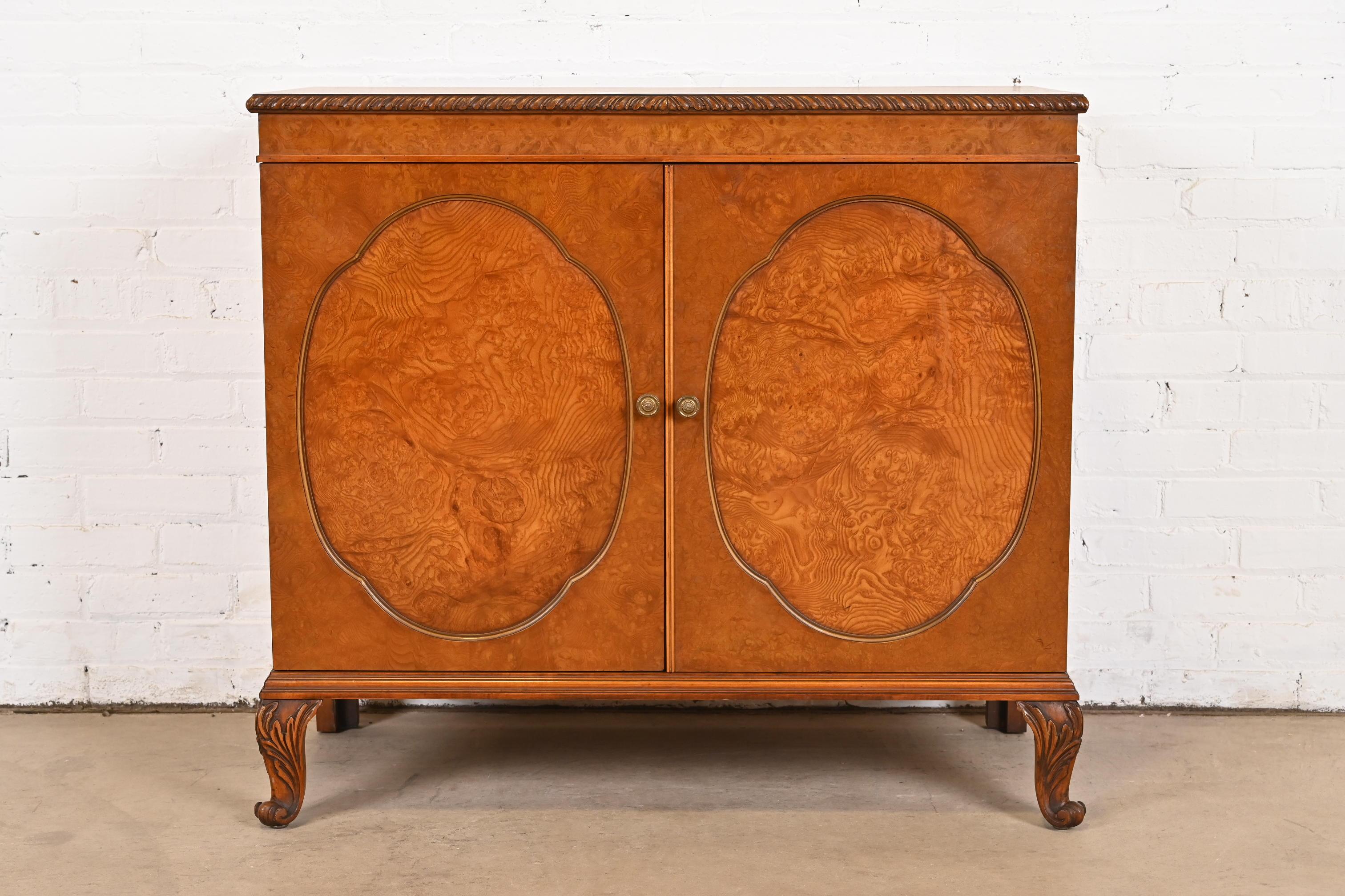 An exceptional French Provincial Louis XV style buffet server or bar cabinet

By Romweber

USA, Circa 1920s

Gorgeous book-matched olive ash burl wood, with original brass hardware.

Measures: 38