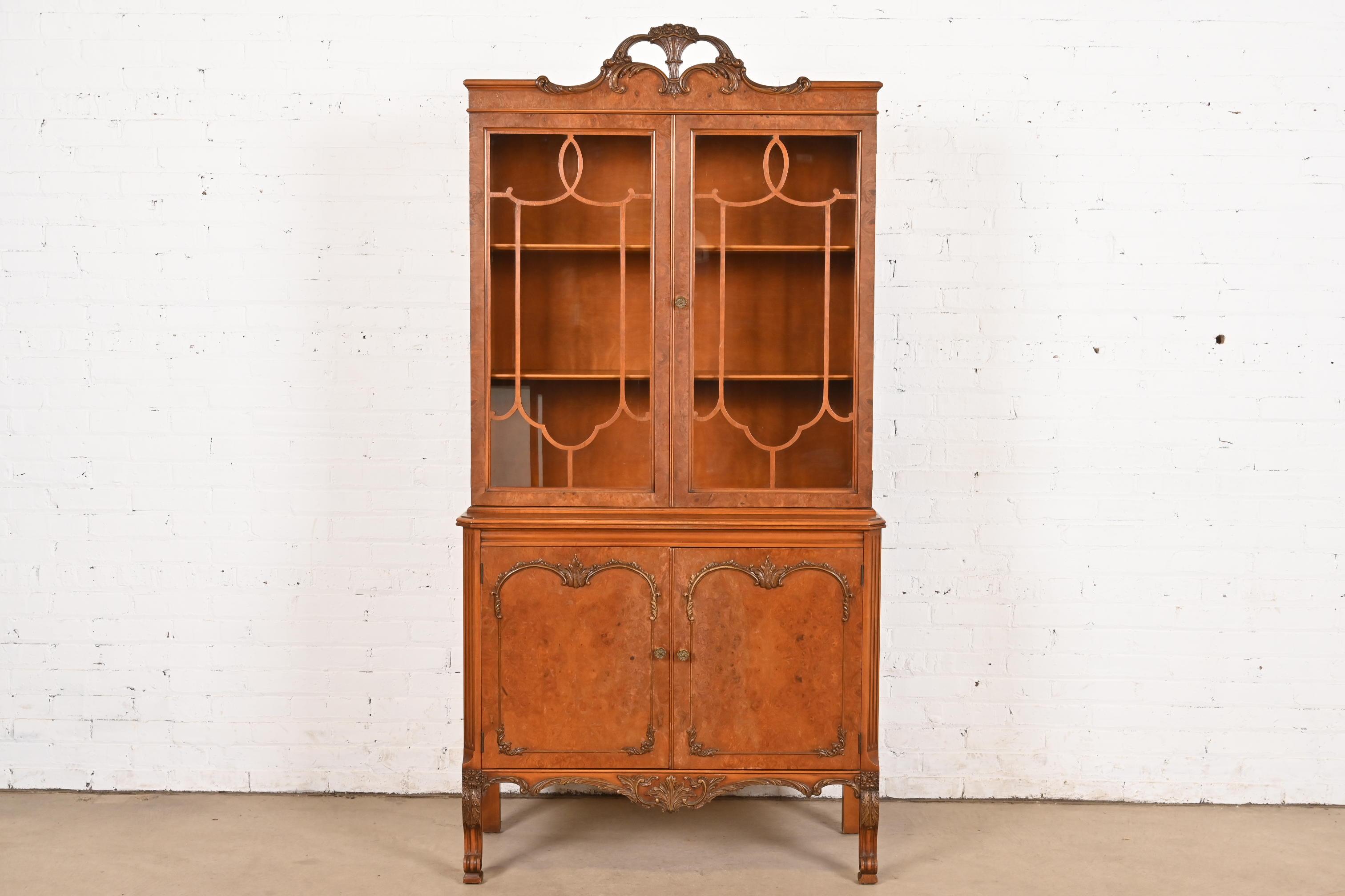 An exceptional French Provincial Louis XV style breakfront bookcase cabinet or dining cabinet

By Romweber

USA, Circa 1920s

Gorgeous book-matched exotic burl wood, with mullioned glass front doors, and original brass hardware.

Measures: 38