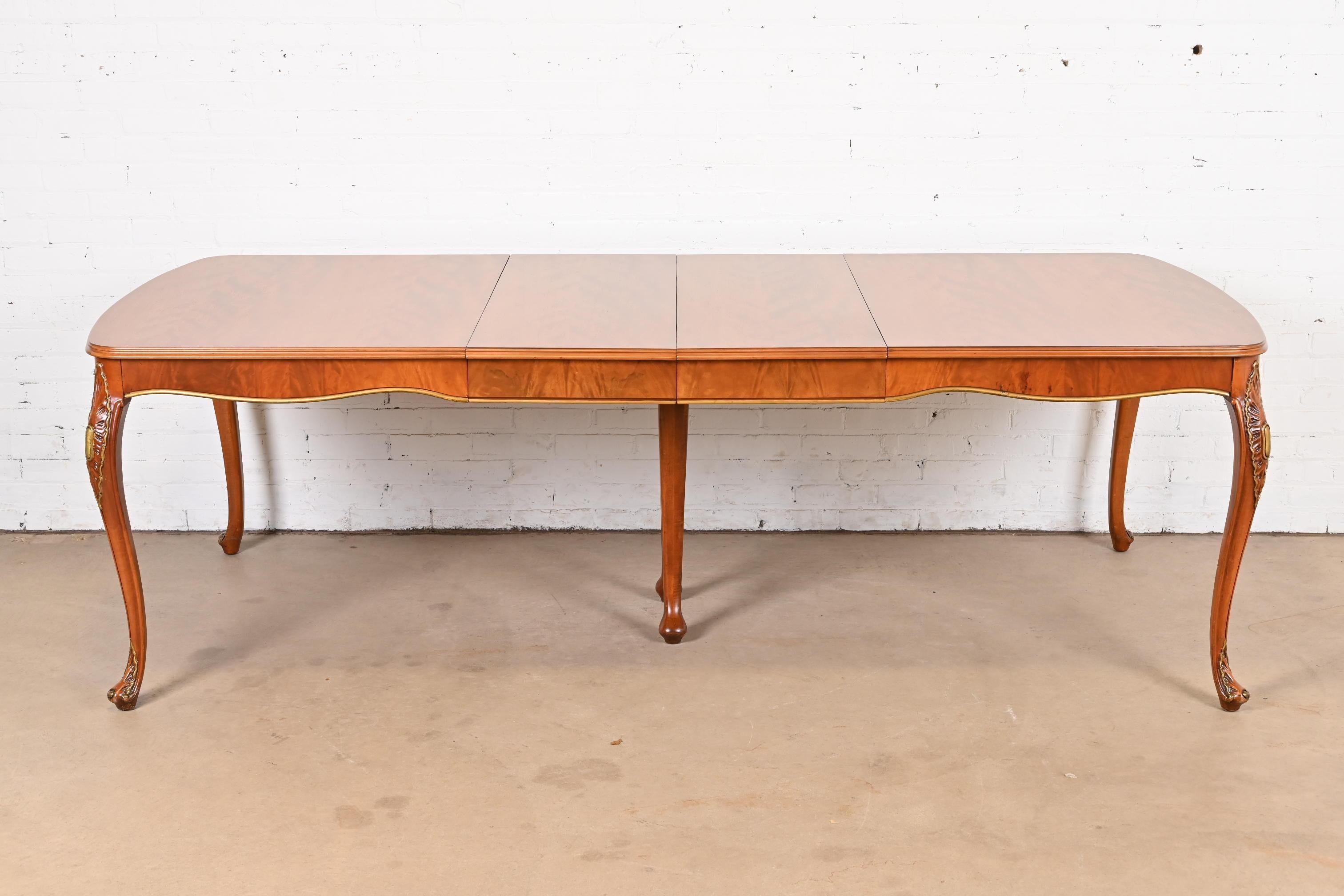 An exceptional French Provincial Louis XV style extension dining table

By Romweber

USA, Circa 1920s

Gorgeous book-matched exotic burled African avodire wood, with gold gilt details.

Measures: 64