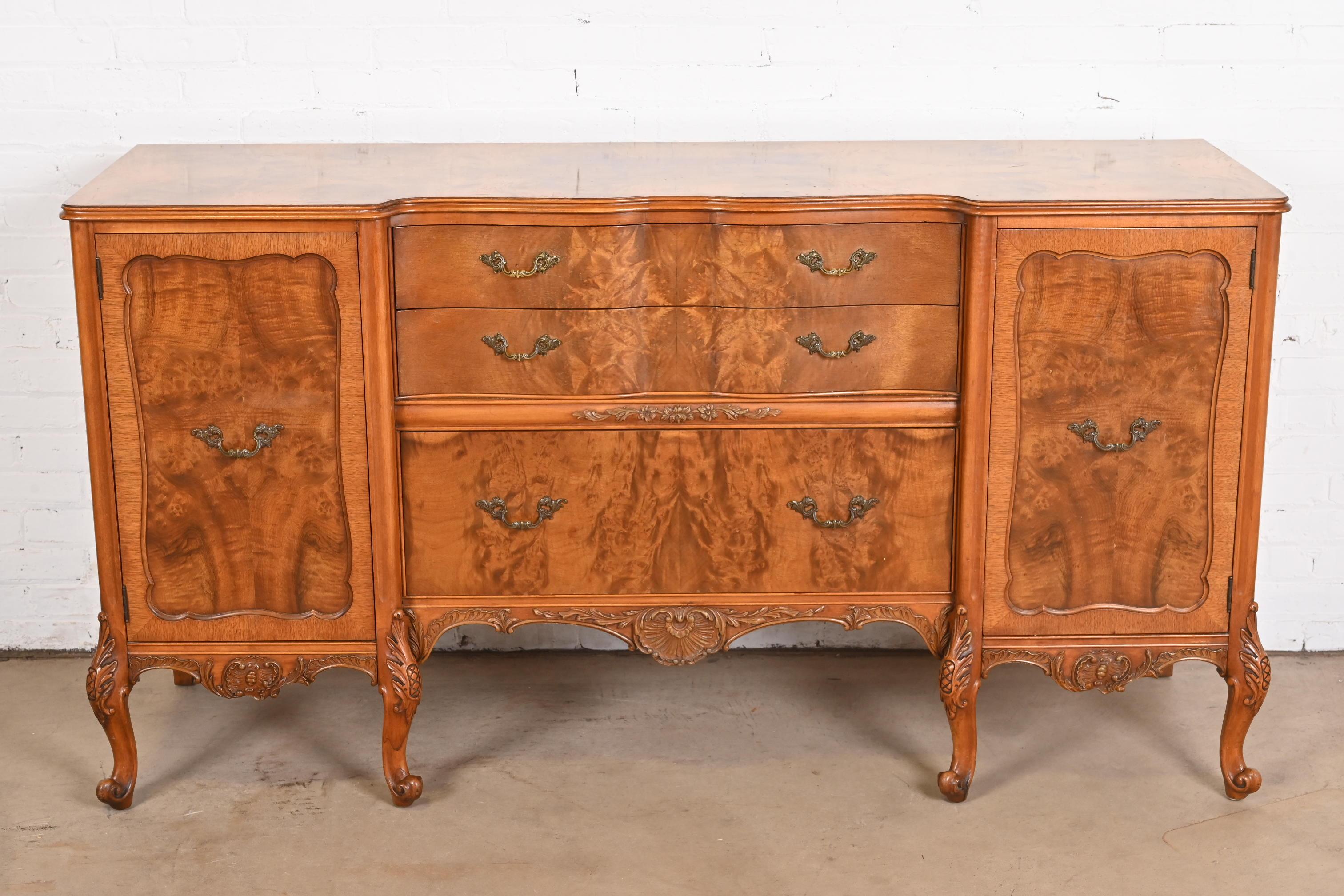 An exceptional French Provincial Louis XV style sideboard, credenza, or bar cabinet

By Romweber

USA, Circa 1920s

Gorgeous book-matched exotic burled acacia wood, with carved cabriole legs, and original brass hardware.

Measures: 68.75