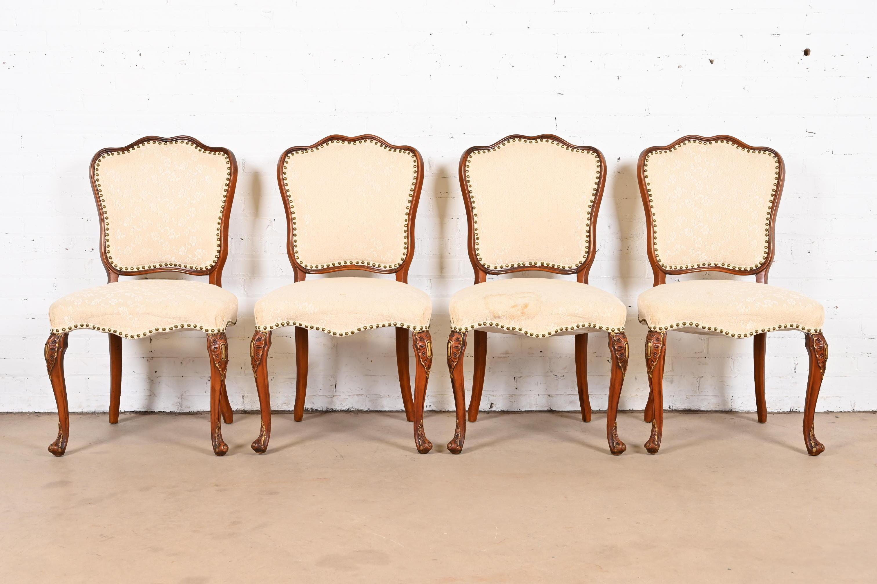 A gorgeous set of four French Provincial Louis XV style dining chairs

By Romweber

USA, Circa 1920s

Beautiful carved solid walnut frames, with gold gilt details, and brass studded floral patterned cream upholstered seats and backs.

Measures:
