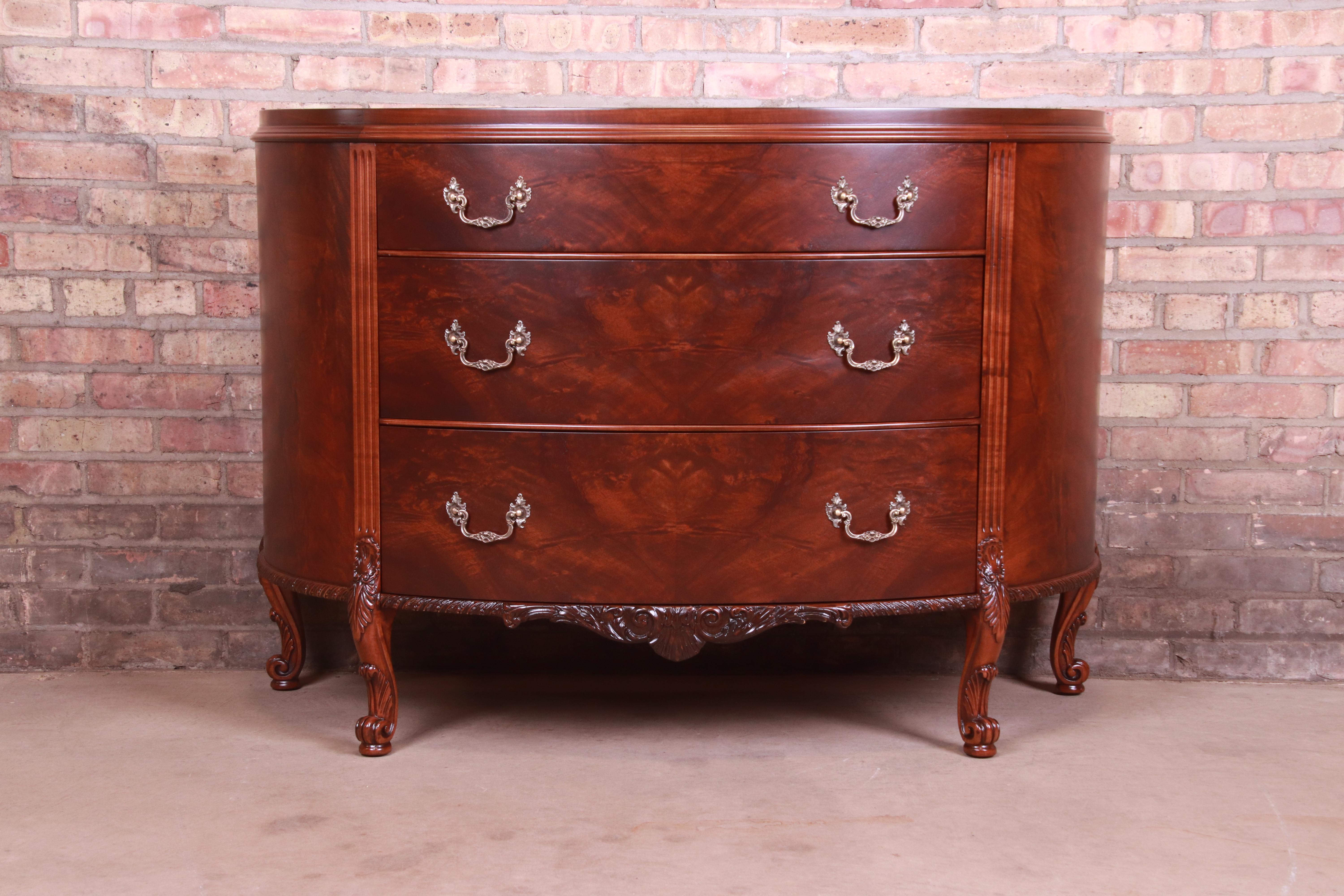 An exceptional French Provincial Louis XV style three-drawer commode or chest of drawers

By Romweber

USA, Circa 1920s

Flame mahogany, with ornate carved mahogany legs and trim and original brass hardware.

Measures: 50.25