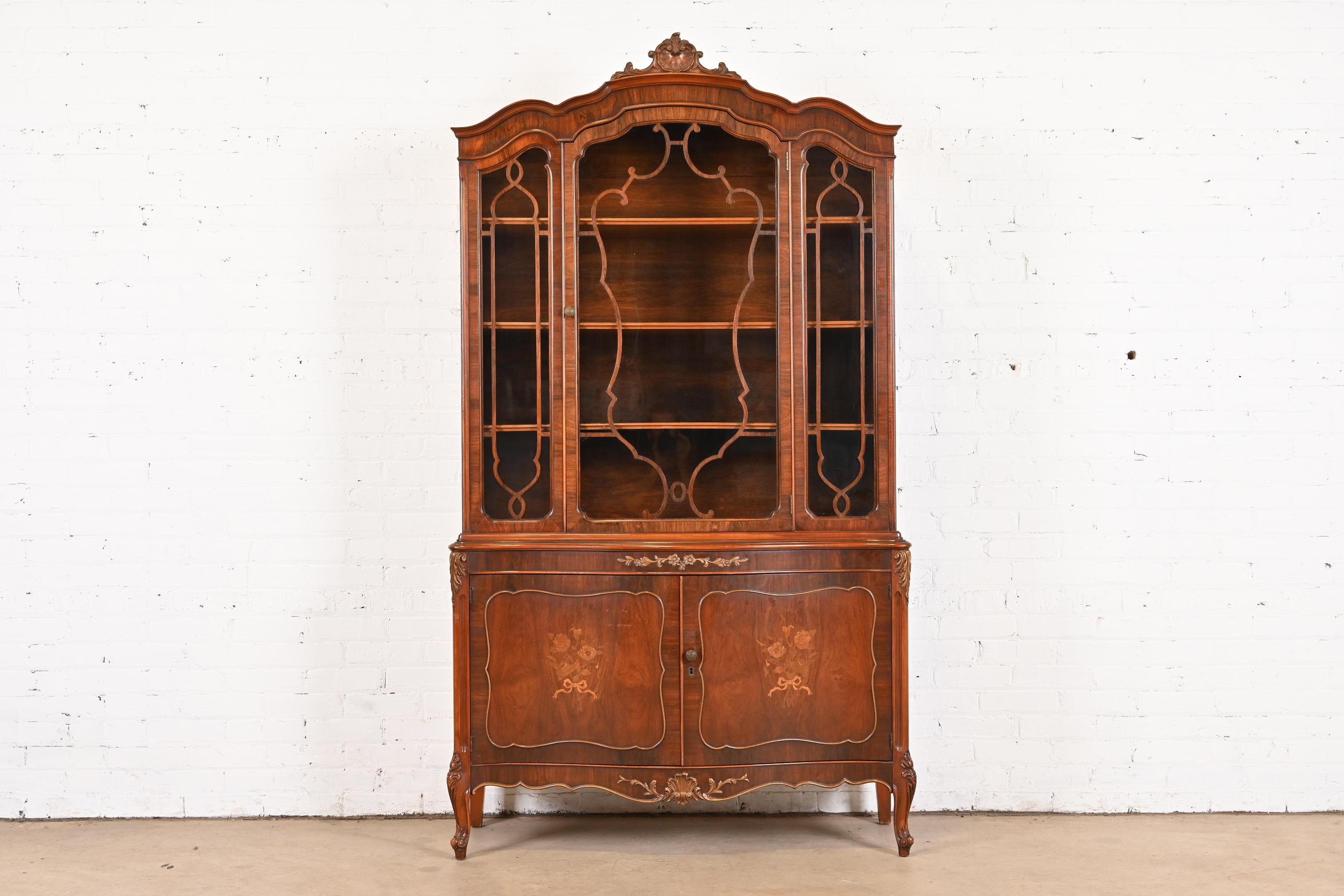 An exceptional French Provincial Louis XV style breakfront bookcase cabinet or dining cabinet

By Romweber

USA, Circa 1920s

Gorgeous carved rosewood, with inlaid satinwood floral marquetry, mullioned glass front doors, and original brass hardware.