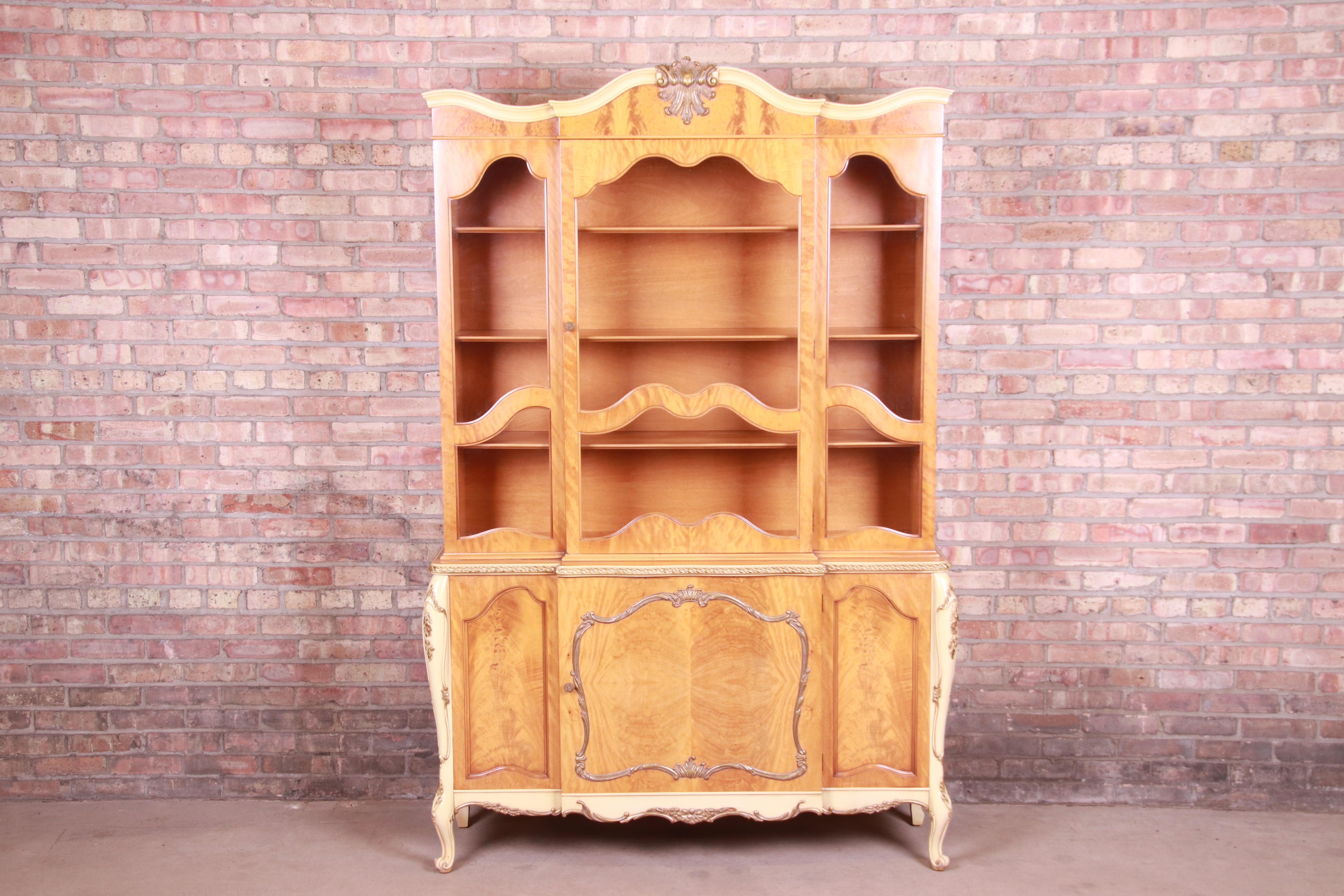 A gorgeous French Rococo Louis XV style china cabinet or bookcase

By Romweber

USA, Circa 1930s

Exotic burled African avodire wood, with paint and gilt details, glass front doors, and original brass hardware.

Measures: 53