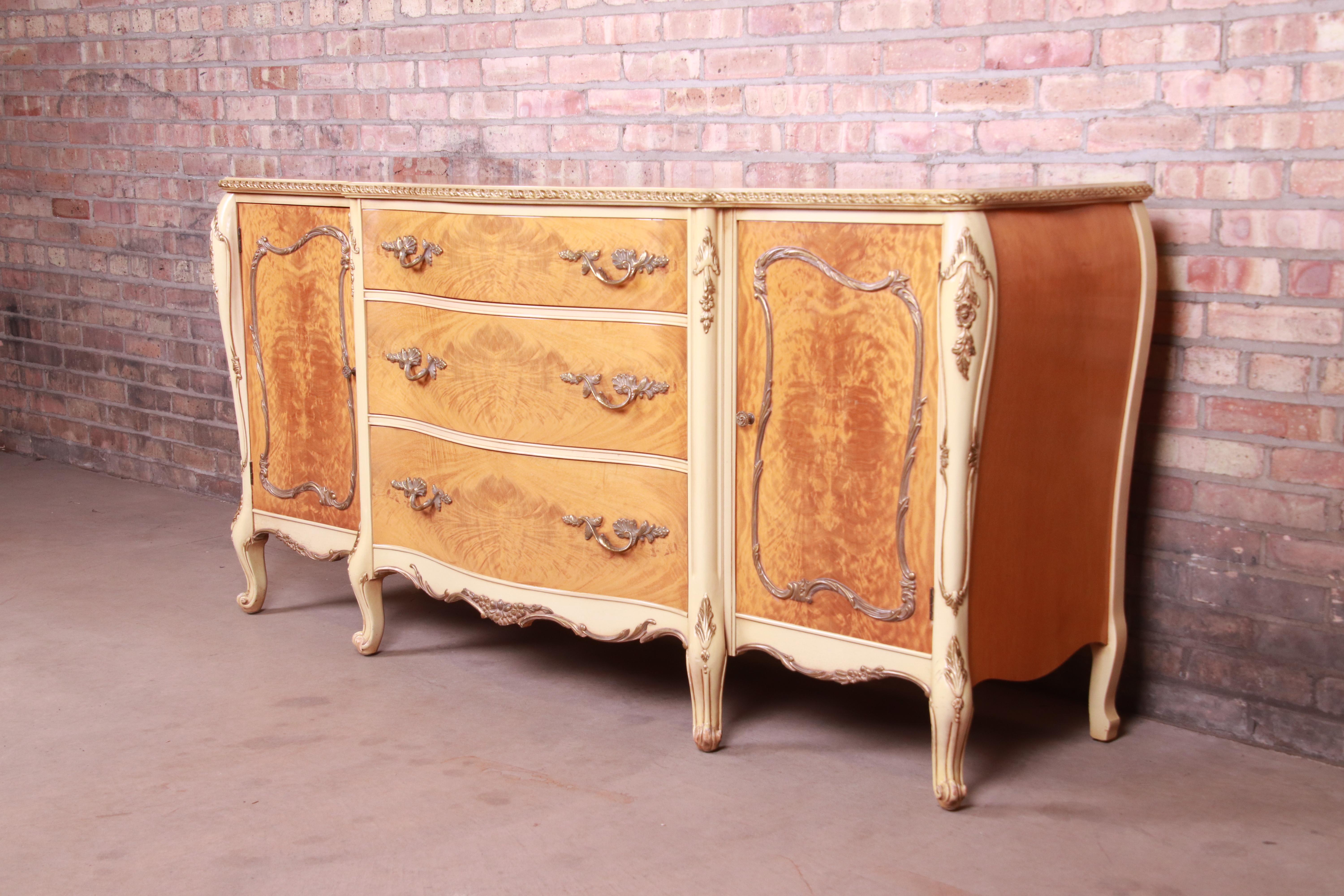 A gorgeous French Rococo Louis XV style sideboard or credenza

By Romweber,

USA, Circa 1930s

Exotic burled African avodire wood, with paint and gilt details and original brass hardware.

Measures: 69