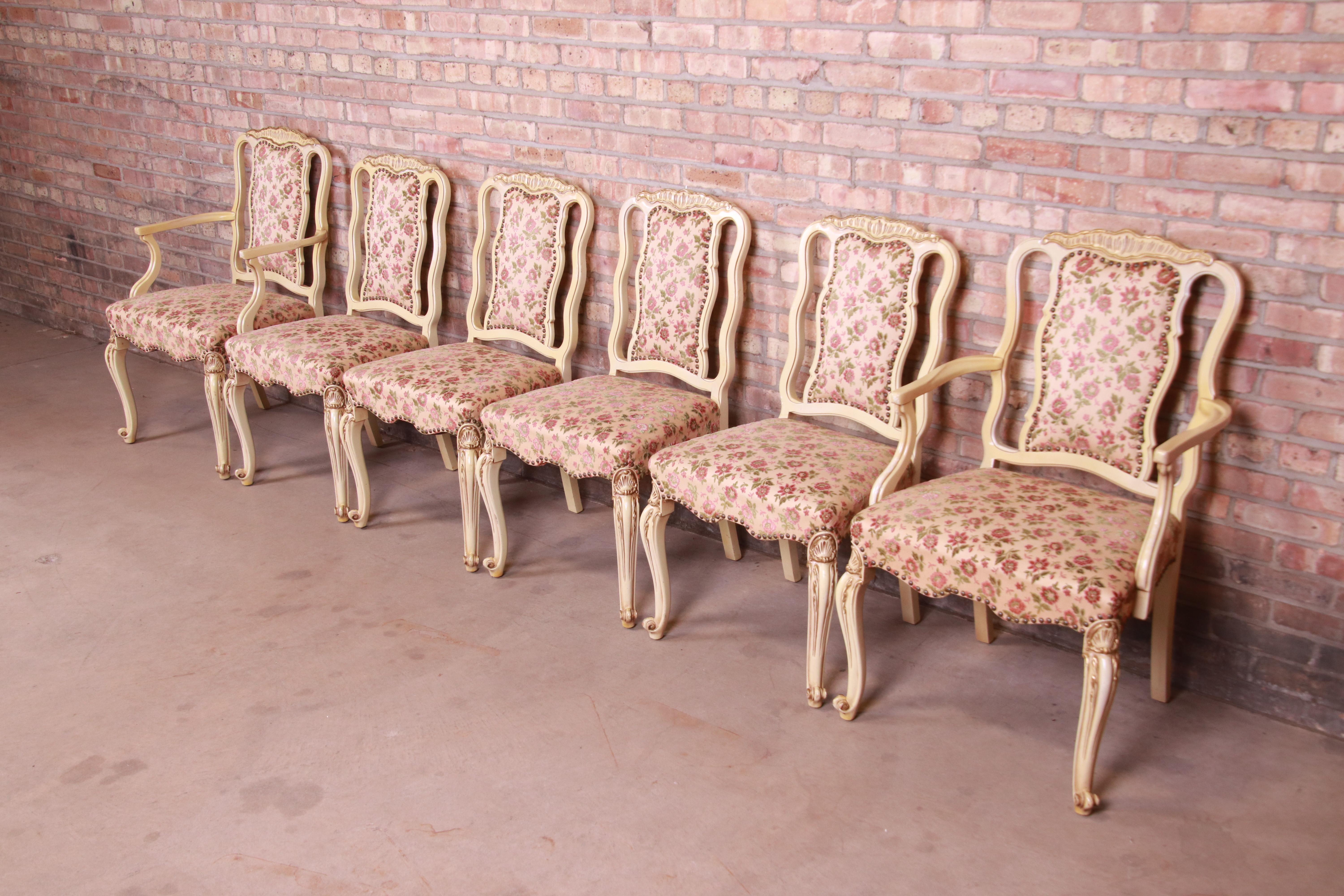 A gorgeous set of six French Rococo or Louis XV style dining chairs

By Romweber

USA, Circa 1930s

Ivory and gold gilt painted wood frames, with studded floral upholstery.

Measures:
Armchairs - 24