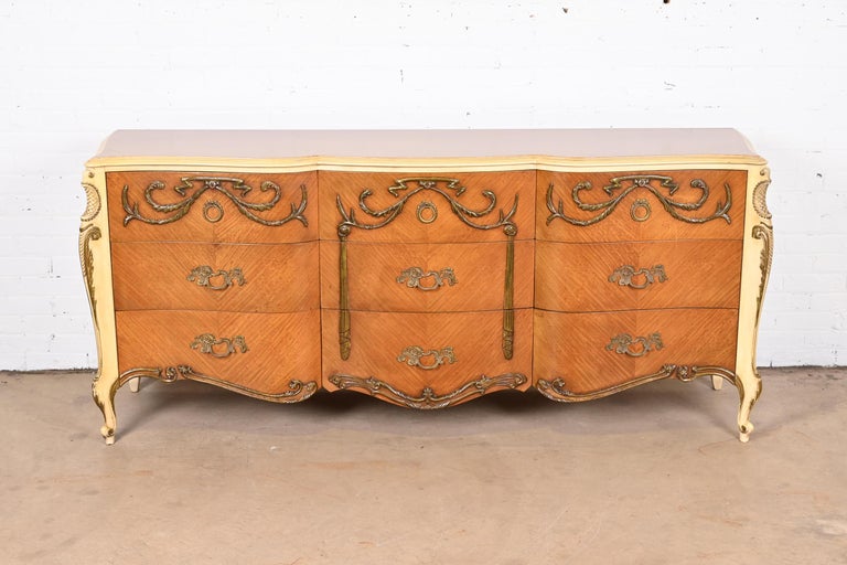 A gorgeous French Rococo Louis XV style triple dresser or credenza

By Romweber

USA, Circa 1940s

Book-matched satinwood, with painted trim and details and original brass hardware.

Measures: 77.75