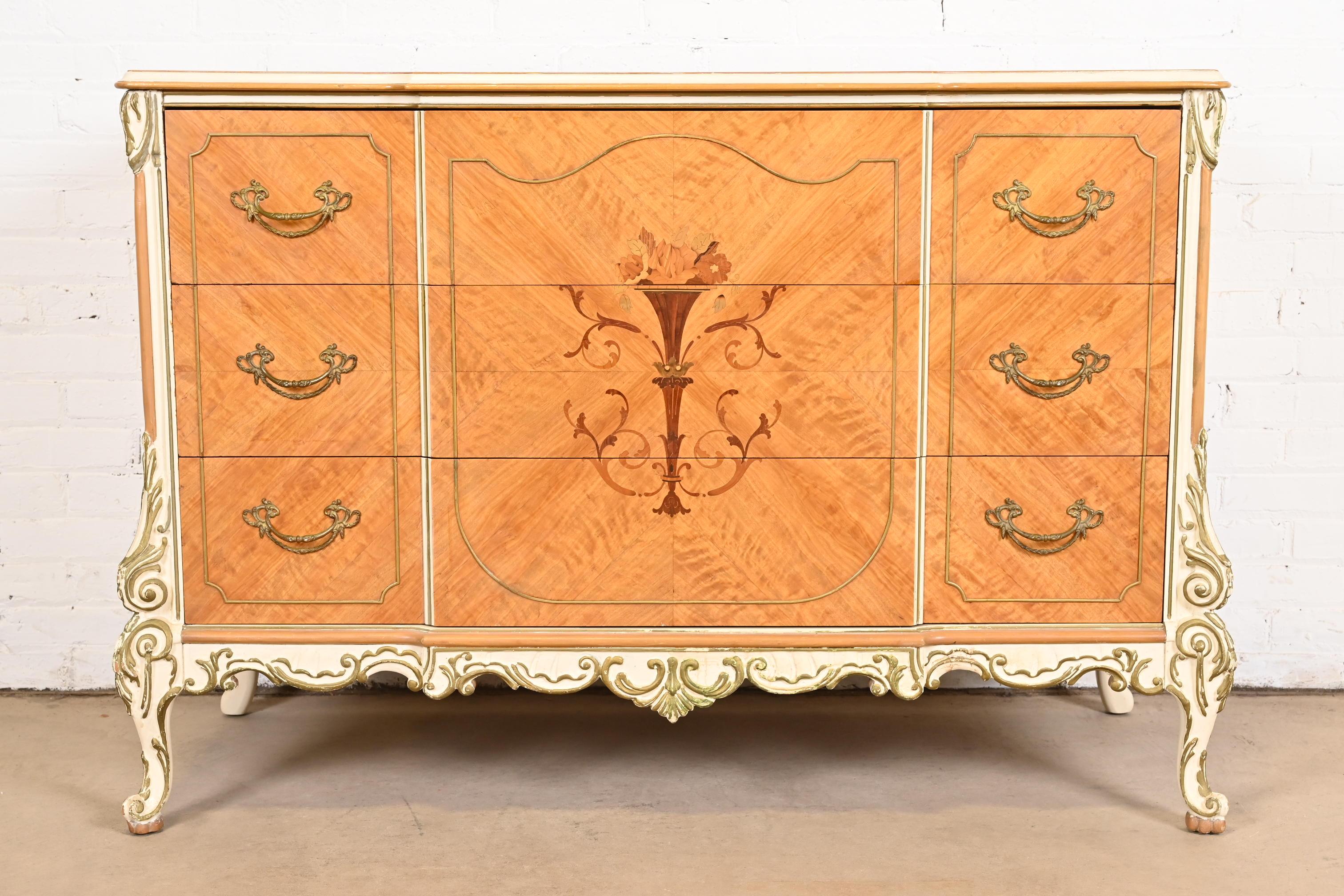 A gorgeous French Rococo Louis XV style three drawer dresser or chest of drawers

By Romweber

USA, Circa 1930s

Beautiful satinwood, with inlaid marquetry, painted and gilt details, and original brass hardware.

Measures: 52.25