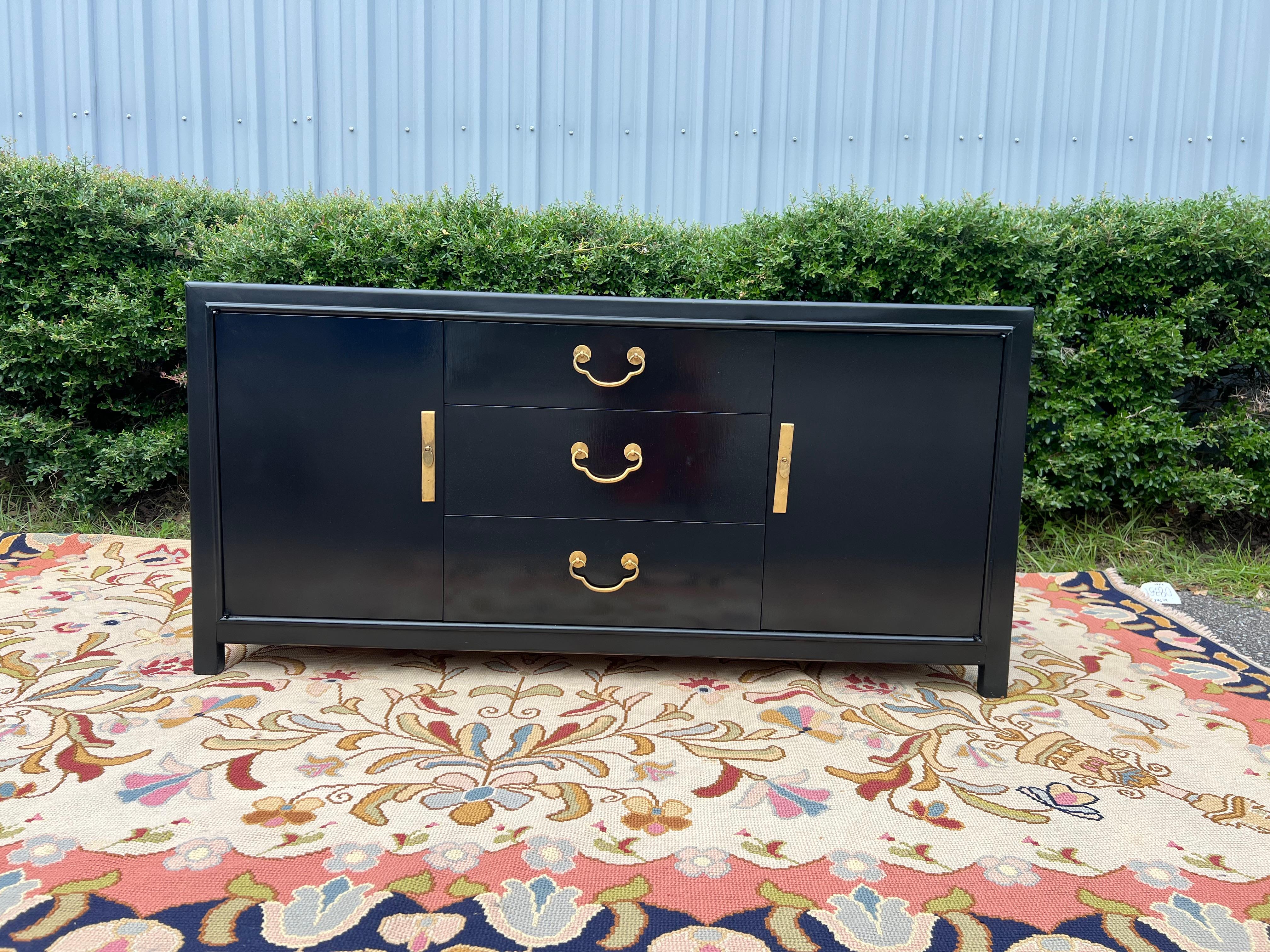 Un'eccezionale cassettiera o credenza Hollywood Regency Chinoiserie della metà del secolo scorso  Da Romweber  USA, Circa anni '50  Teak laccato nero, con ferramenta e accenti originali in ottone di ispirazione asiatica.   3 cassetti al centro