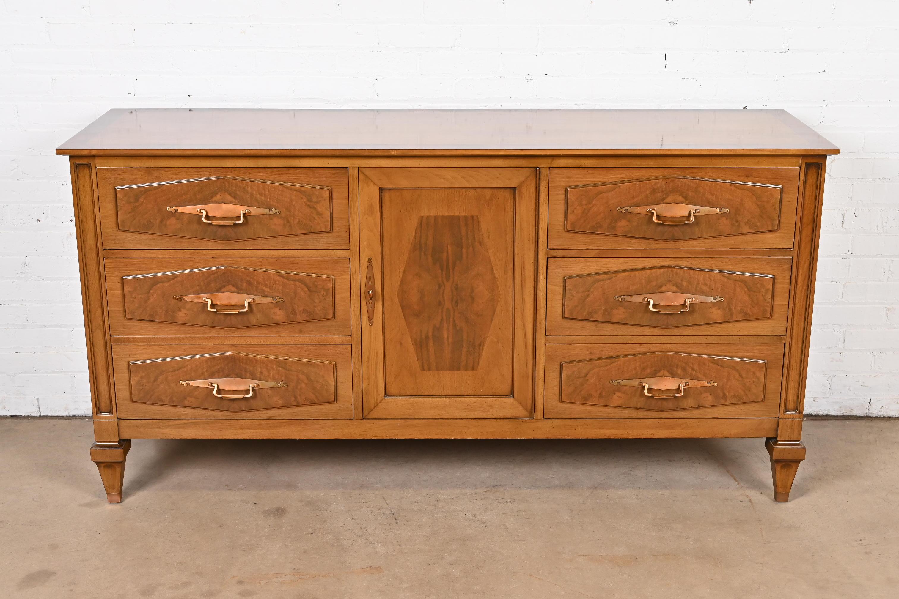 A gorgeous Mid-Century Modern Hollywood Regency dresser or credenza

By Romweber Furniture

USA, Circa 1960s

Walnut, with inlaid burled walnut, and original brass hardware.

Measures: 68