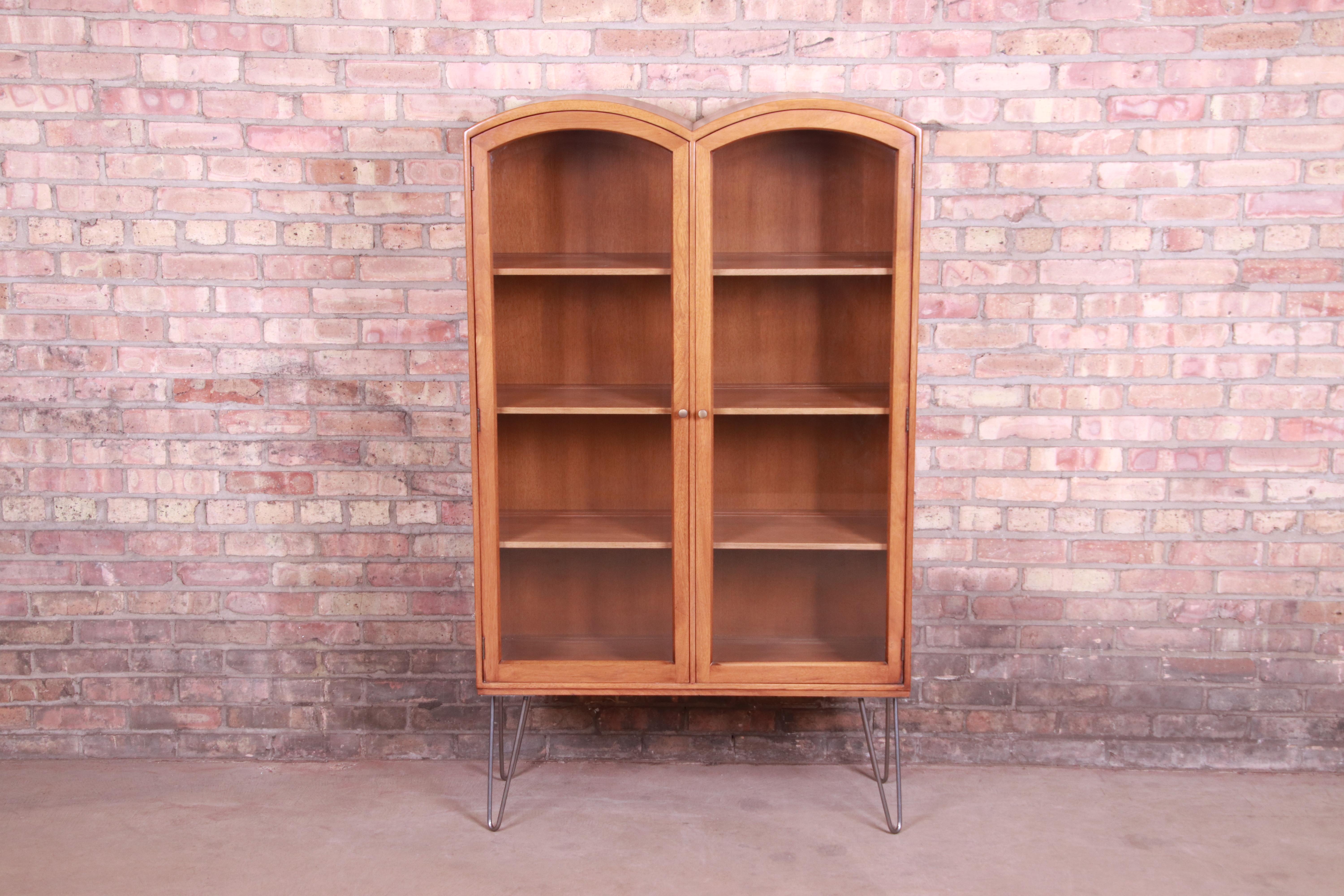 An exceptional Mid-Century Modern bookcase cabinet on hairpin legs

By Romweber

USA, circa 1950s

Walnut, with beveled glass doors and steel hairpin legs.

Measures: 35.25