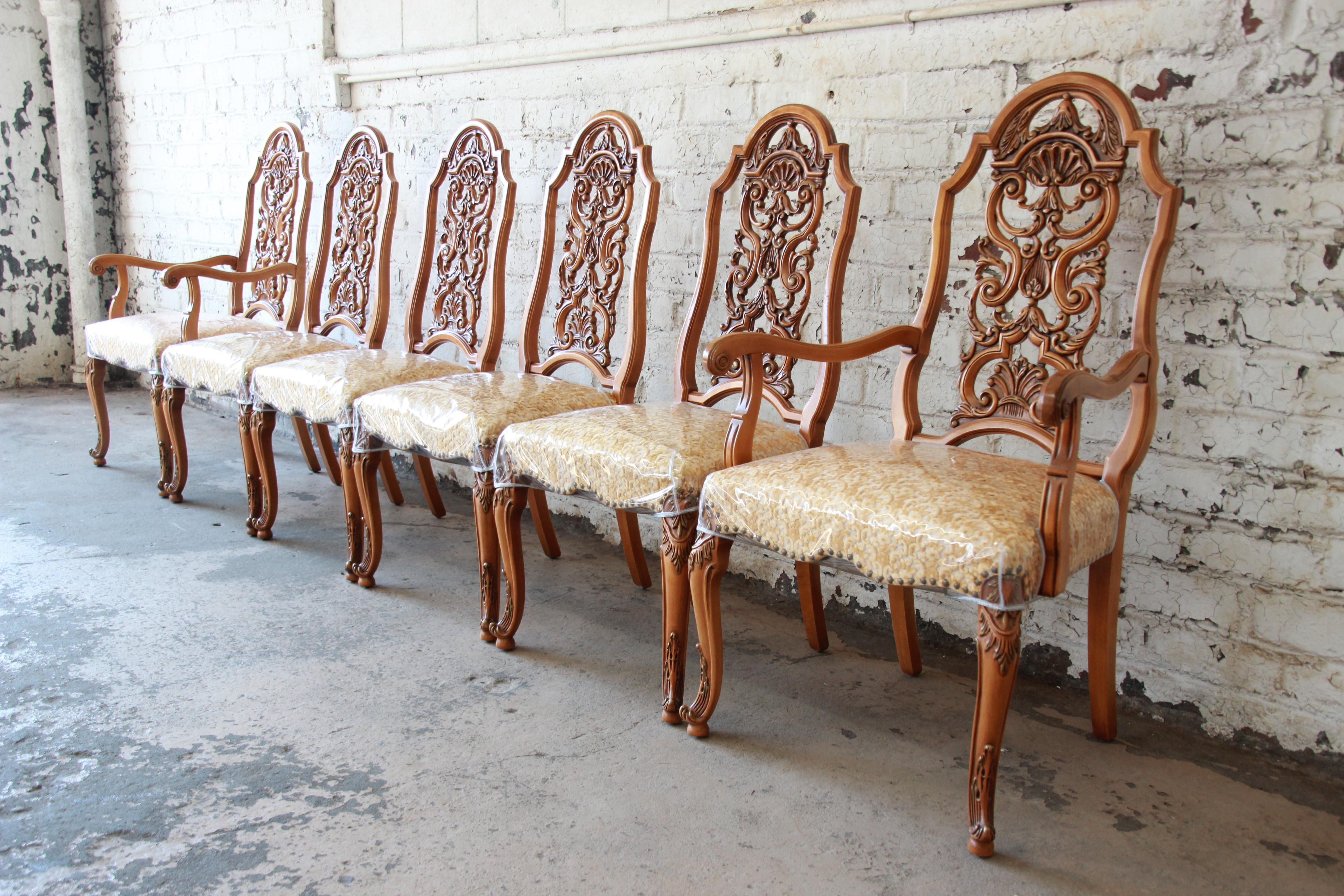 An outstanding set of six ornate French carved dining chairs by Romweber. The set includes two armchairs and four side chairs. The chairs are constructed from solid hardwood with superior quality and the highest attention to detail. The studded