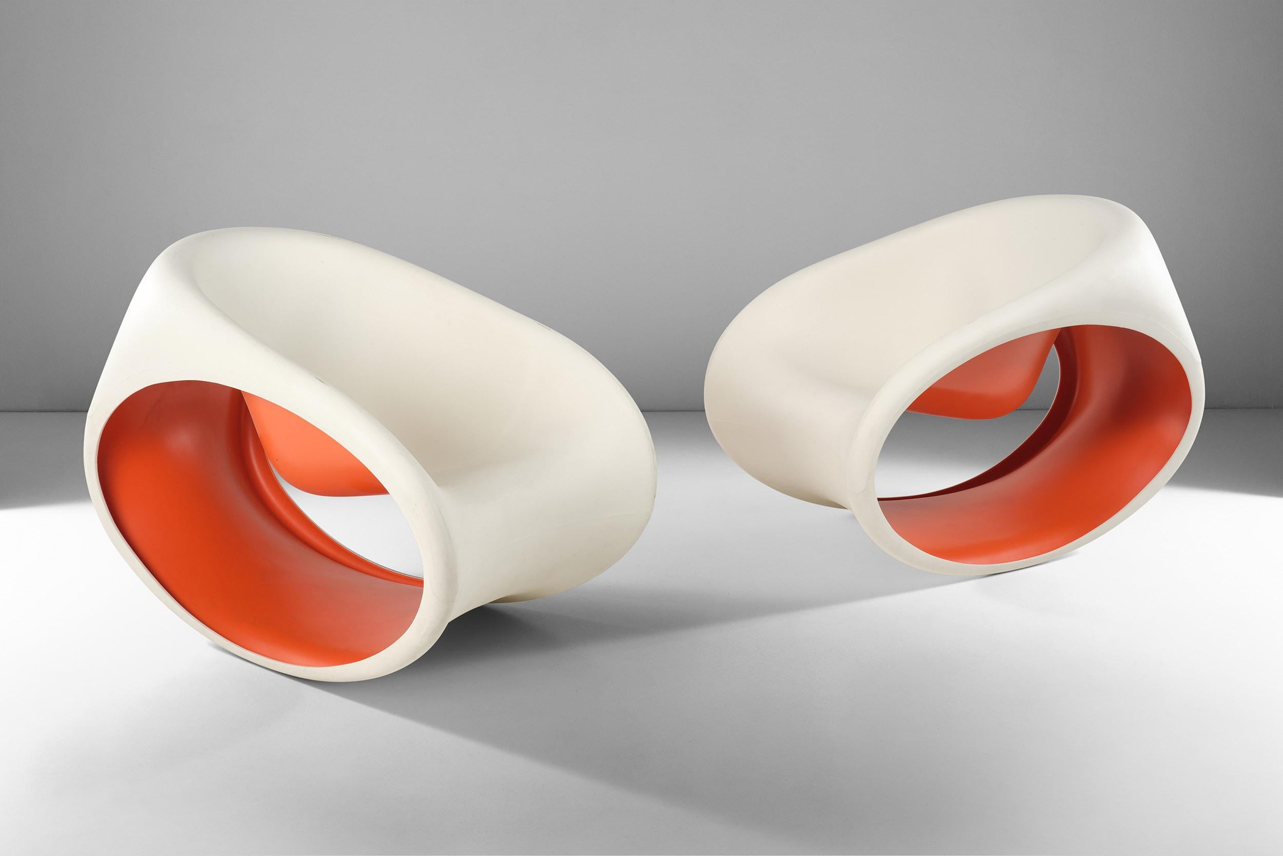 Ces chaises à bascule MT3 ont été conçues par Ron Arad pour Driade et sont fabriquées en polyéthylène monobloc moulé par rotation, de couleur blanc sable à l'extérieur et rouge à l'intérieur. 
Caractérisée par sa forme lisse et son design épuré, sa