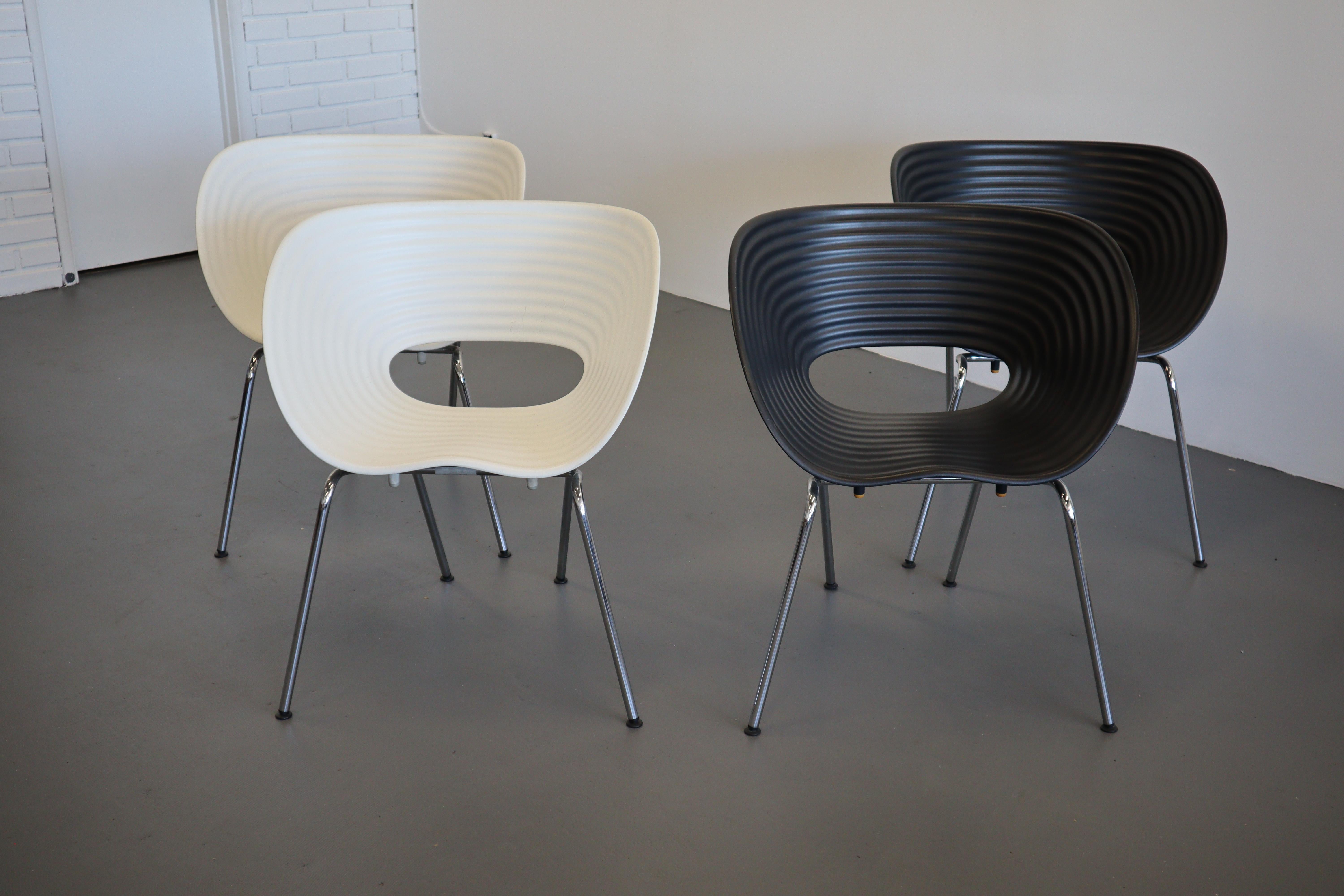 Dual use ribbed scoop seating with oval aperture and chrome tubular legs. This set of four black and white chairs remains as one of the most recognized designs by Tom Vac and Ron Arad for Vitra. Stackable and extremely durable, these are great for