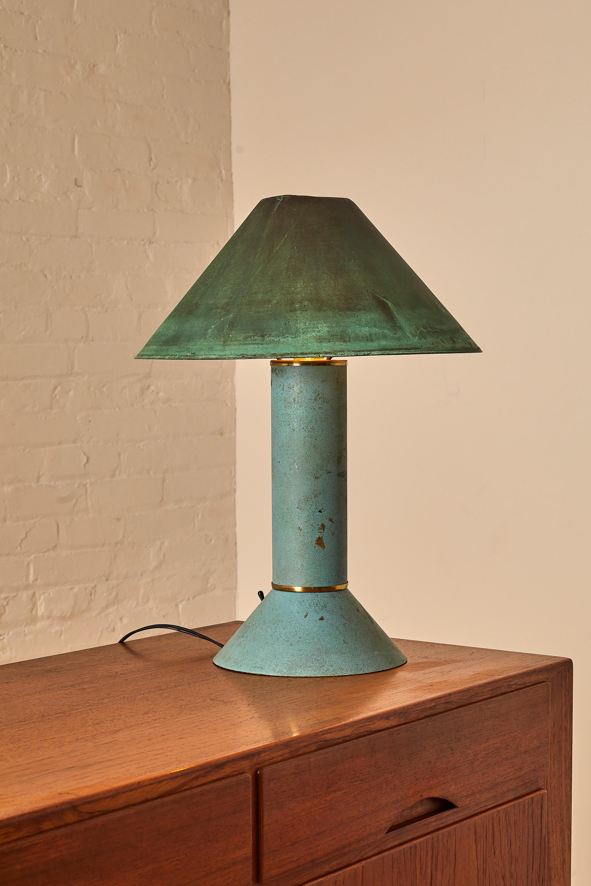Postmodern Ron Rezek California copper table lamp. Classic form and motif of the era in patina copper. White enamel reflector shade attaches to base, outer copper shade rests on top.