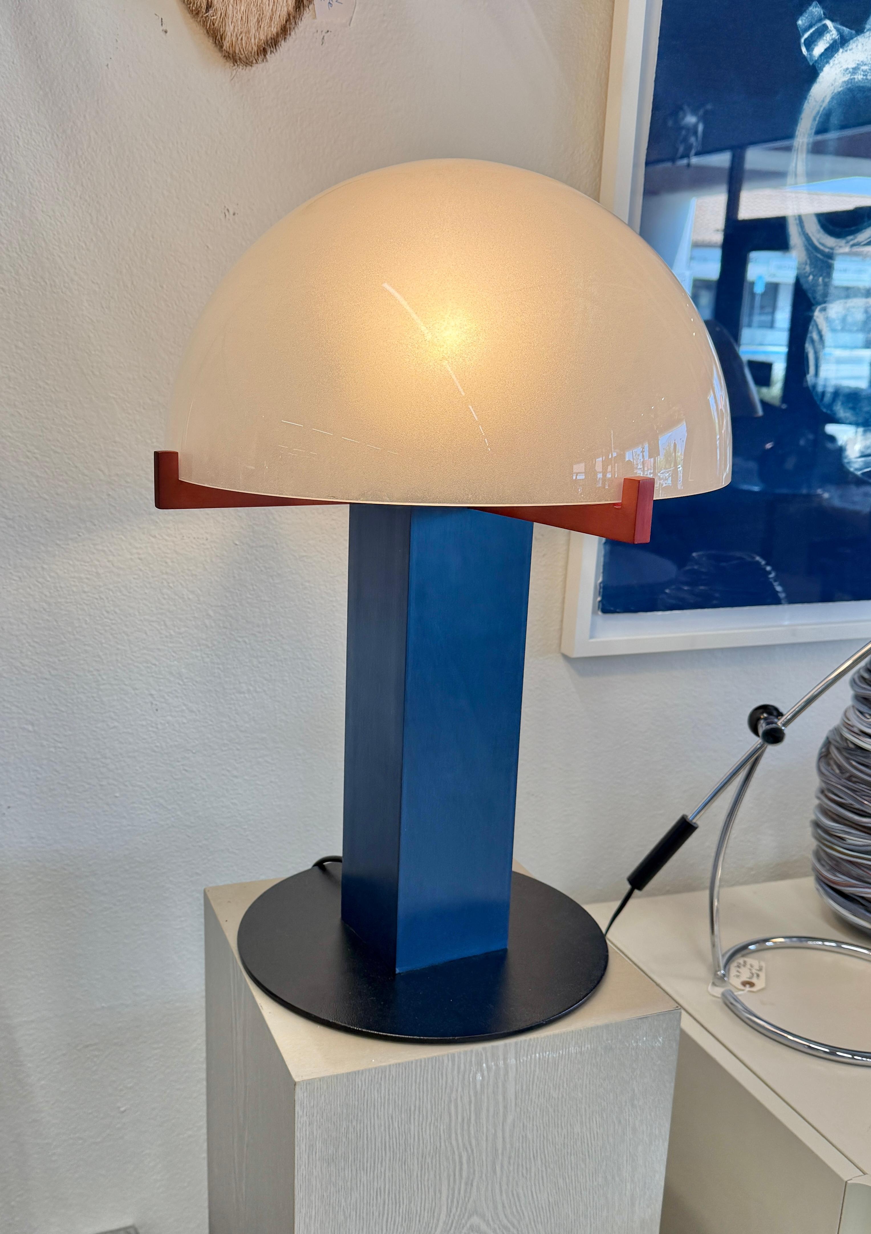 Une lampe Post Modern fonctionnelle très cool conçue par Ron Rezek dans les années 1980. Elle est dotée d'un abat-jour en verre dépoli et d'un colum carré en acier peint monté sur une lourde base circulaire en fer. Fréquemment appelée lampe à