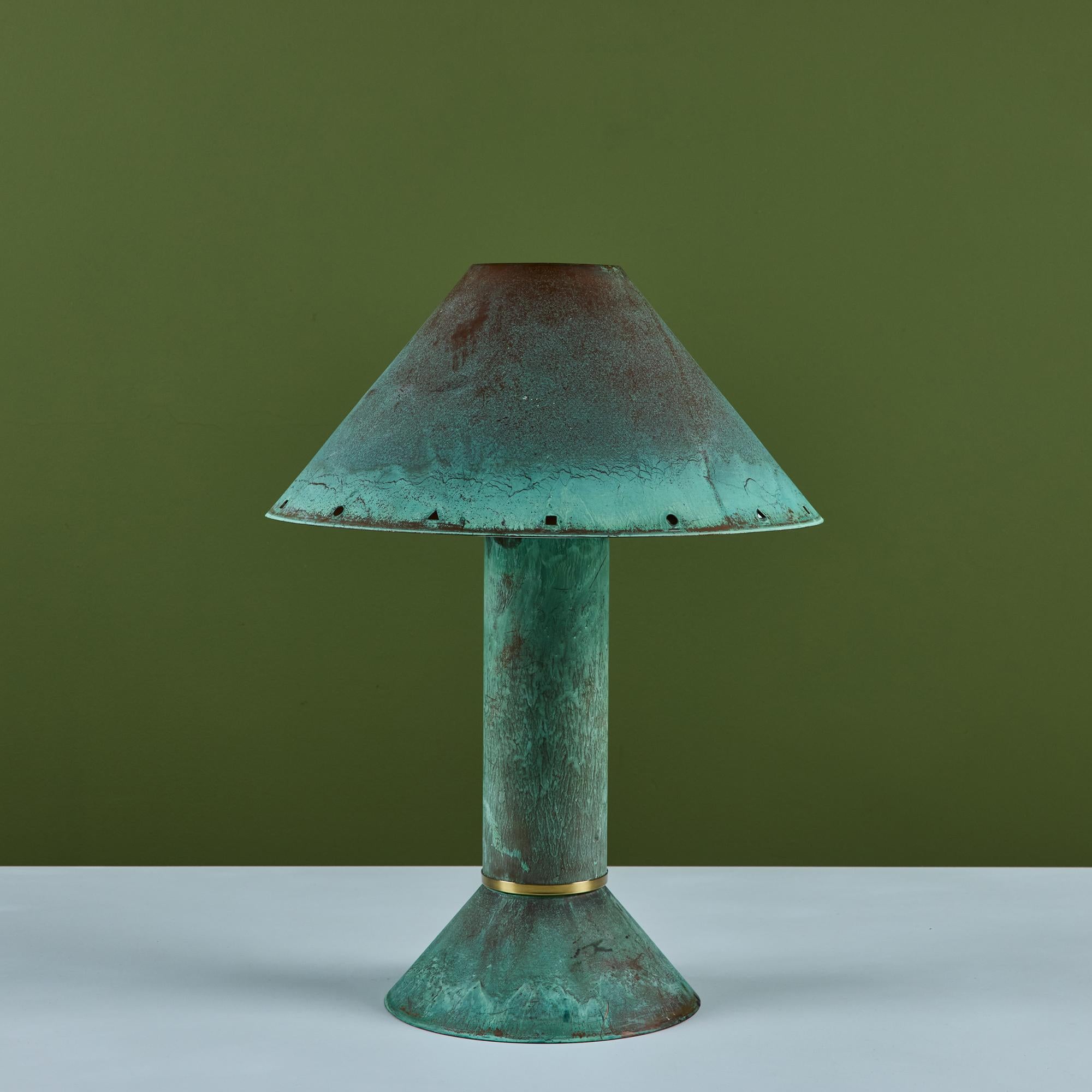 Postmodern table lamp by Los Angeles lighting designer Ron Rezek, c.1980s. The lamp features a verdigris copper frame and removable shade with polished brass ring accent that sits at the bottom of cone shaped base. The shade features different