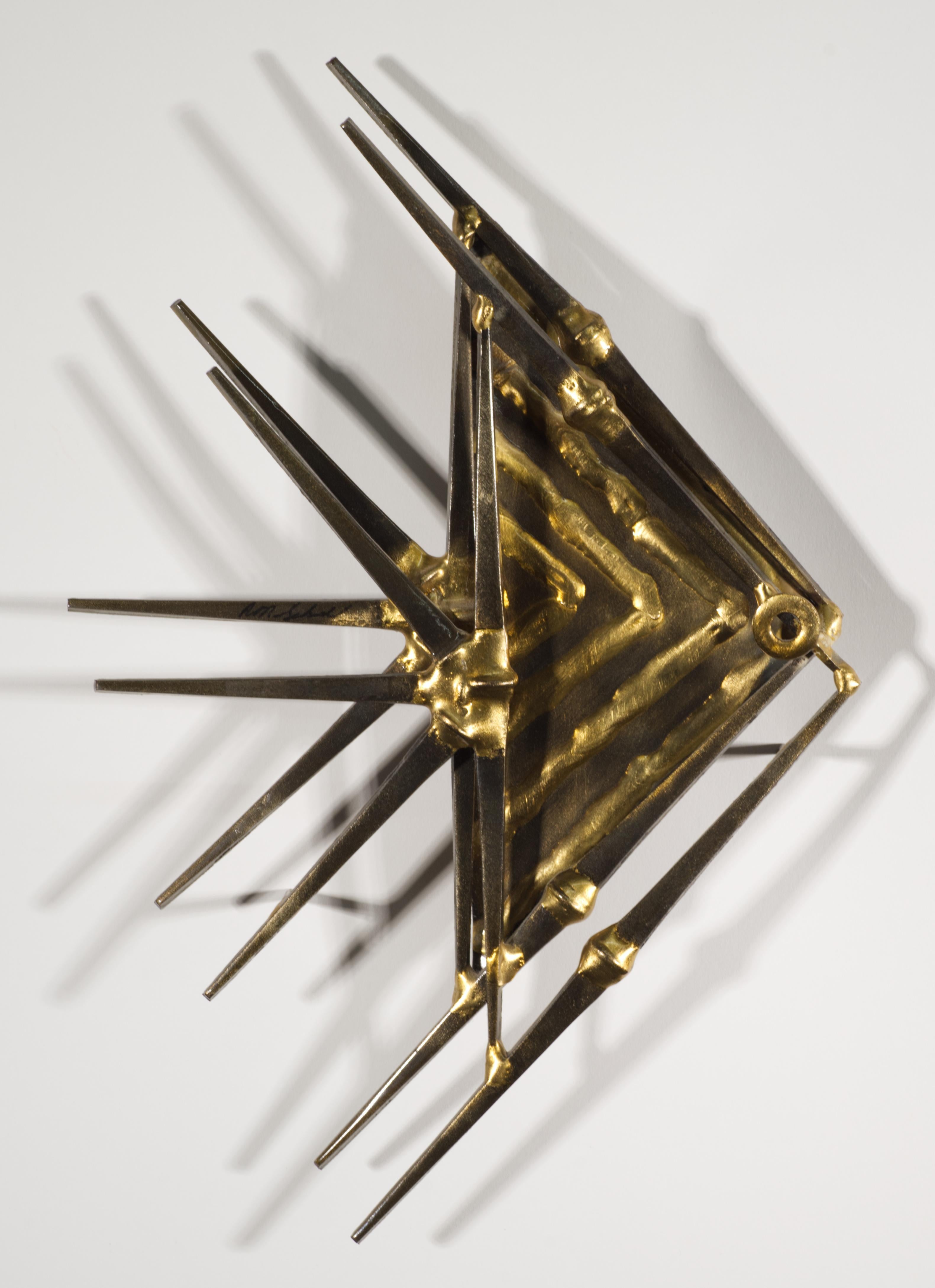  La escultura de pared de clavos vintage presenta un diseño brutalista triangular de un pez rodeado por un patrón en abanico de pinchos individuales. La escultura está equipada con una percha redonda y soportes laterales en la parte posterior.

La