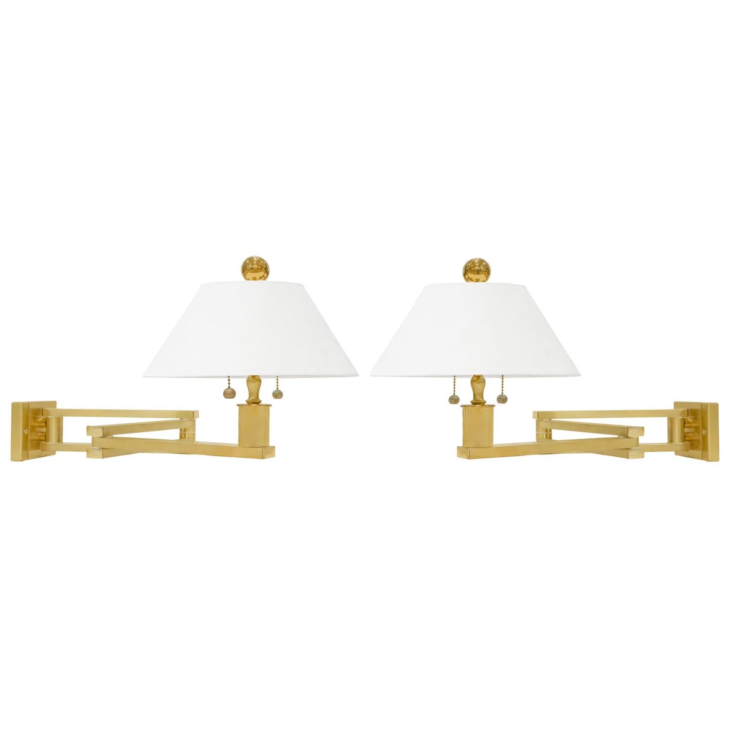 Pair of meticulously crafted swing-arm wall lamps in satin brass, each with 2 bulbs, by Ron Seff, American 1980's. Ron Seff worked for Karl Springer for years before going off on his own.  Each comes with a back mounting plate.  The craftsmanship on