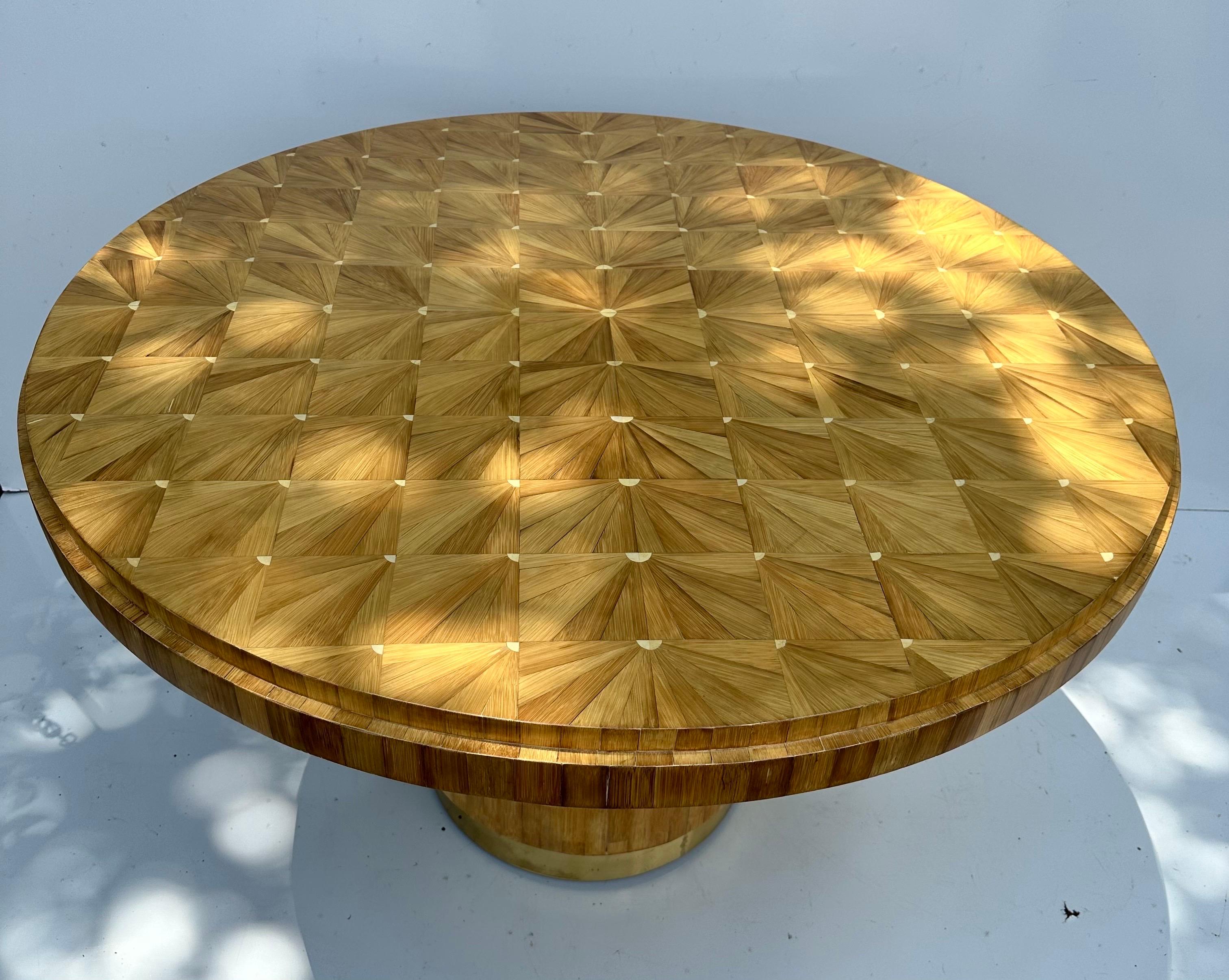 Ron Seff Raffia wood marquetry dining table with round form and brass mounted base. Completed with thick glass table top. 