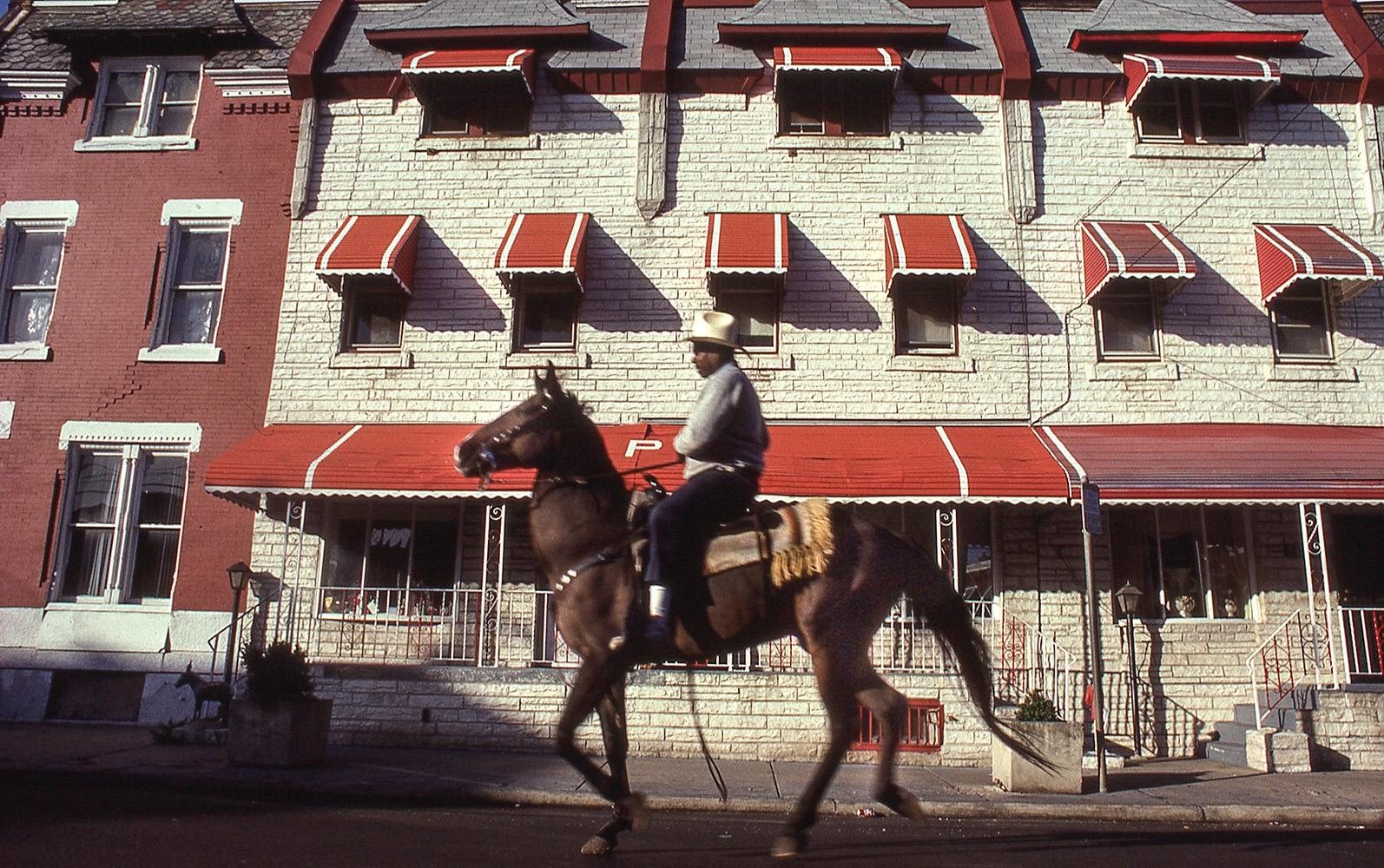 Ron Tarver Figurative Photograph - Ride By Rows: photo of Black urban cowboy in Philadelphia city