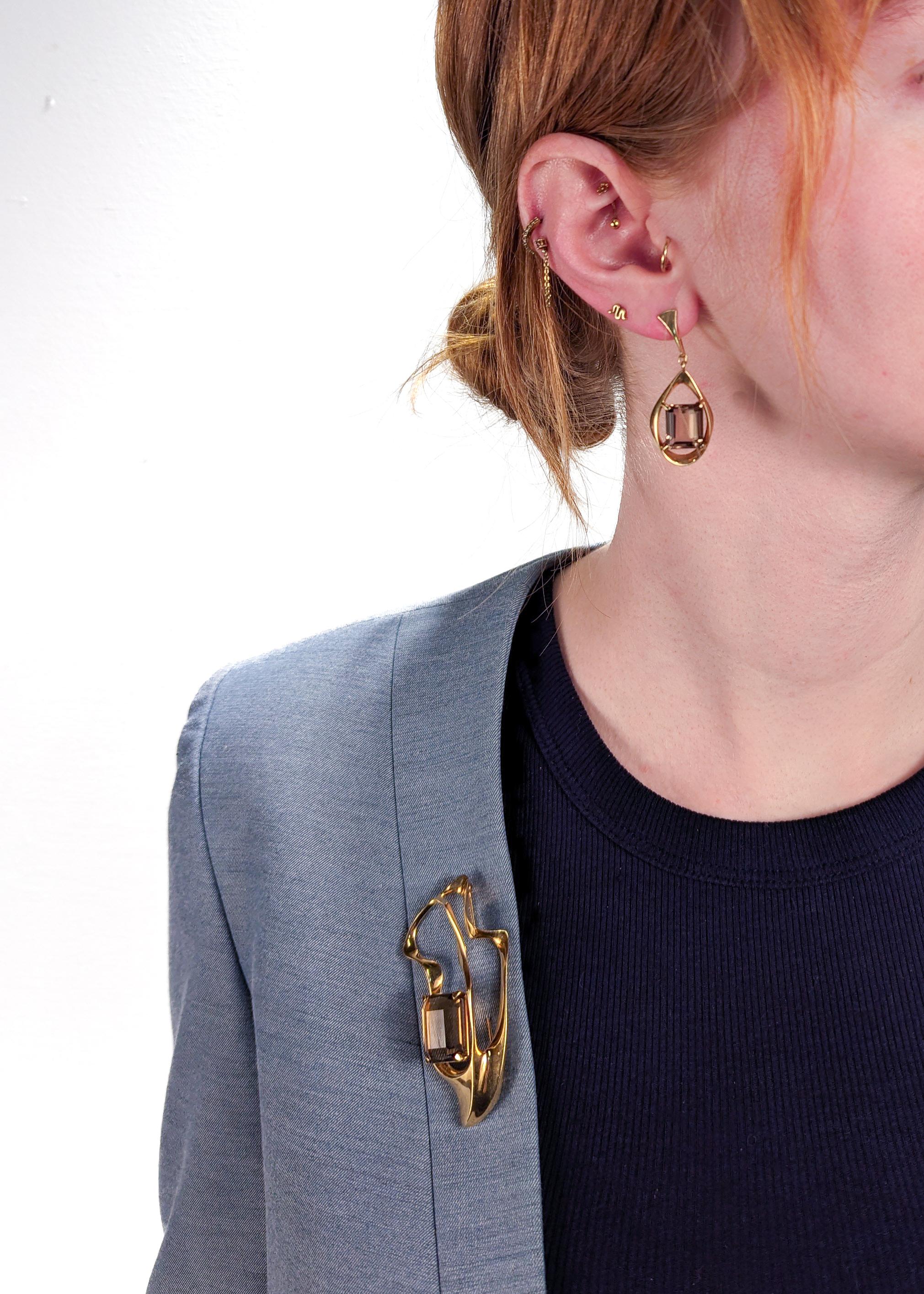 A wonderful earrings and brooch set by Ronald Hayes Pearson.

Comprised of 14-karat forged yellow gold set with emerald-cut topaz gemstones. 

The earrings are clip-ons, and the brooch is secured with its pin back.

Both earrings and brooch are