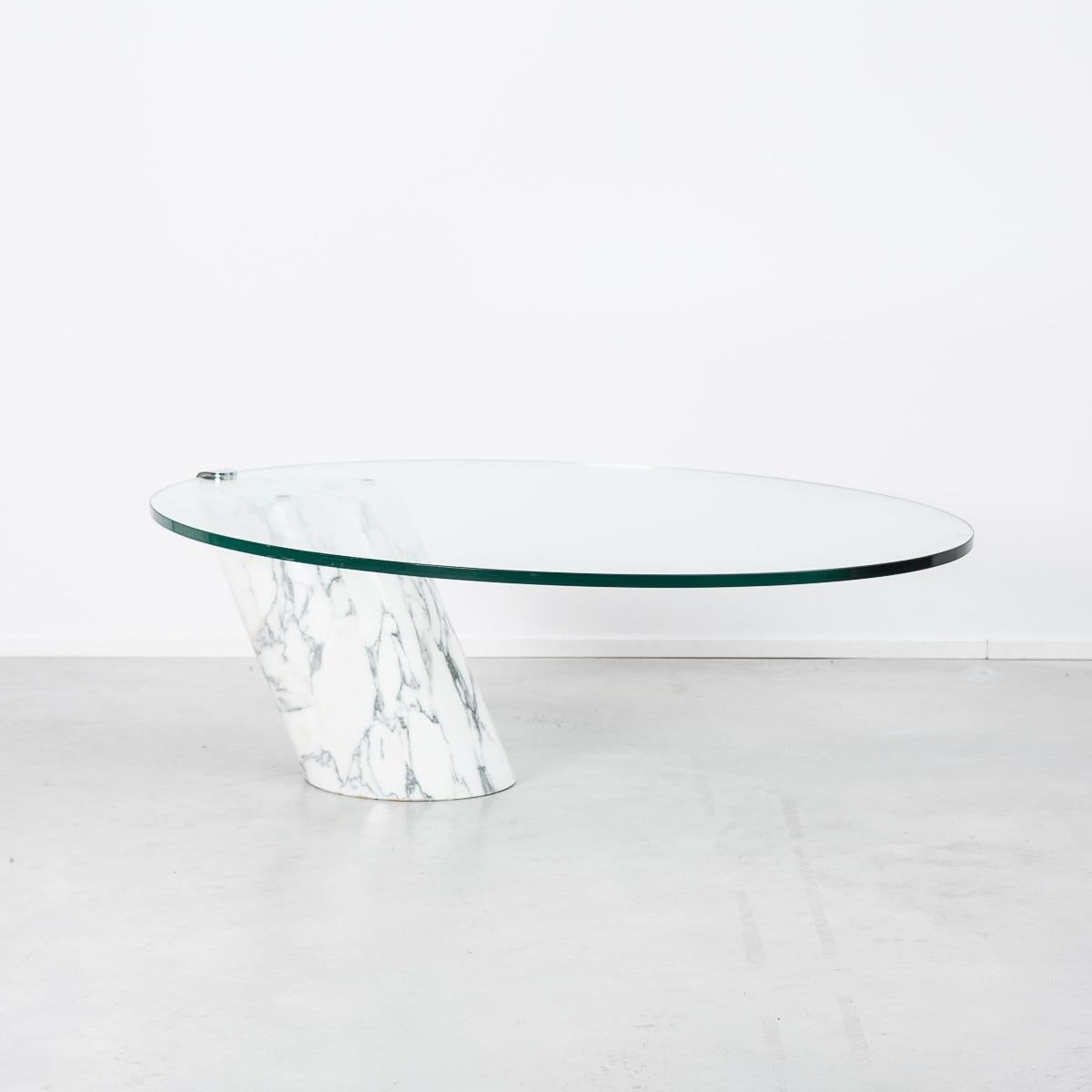 This remarkable cantilevered coffee table was designed by Frans Hero and Karl Odermatt for Swiss company Ronald Schmitt. The thick glass top is fixed to the marble base by a single metal bracket giving it a gravity defying effect. As you can imagine